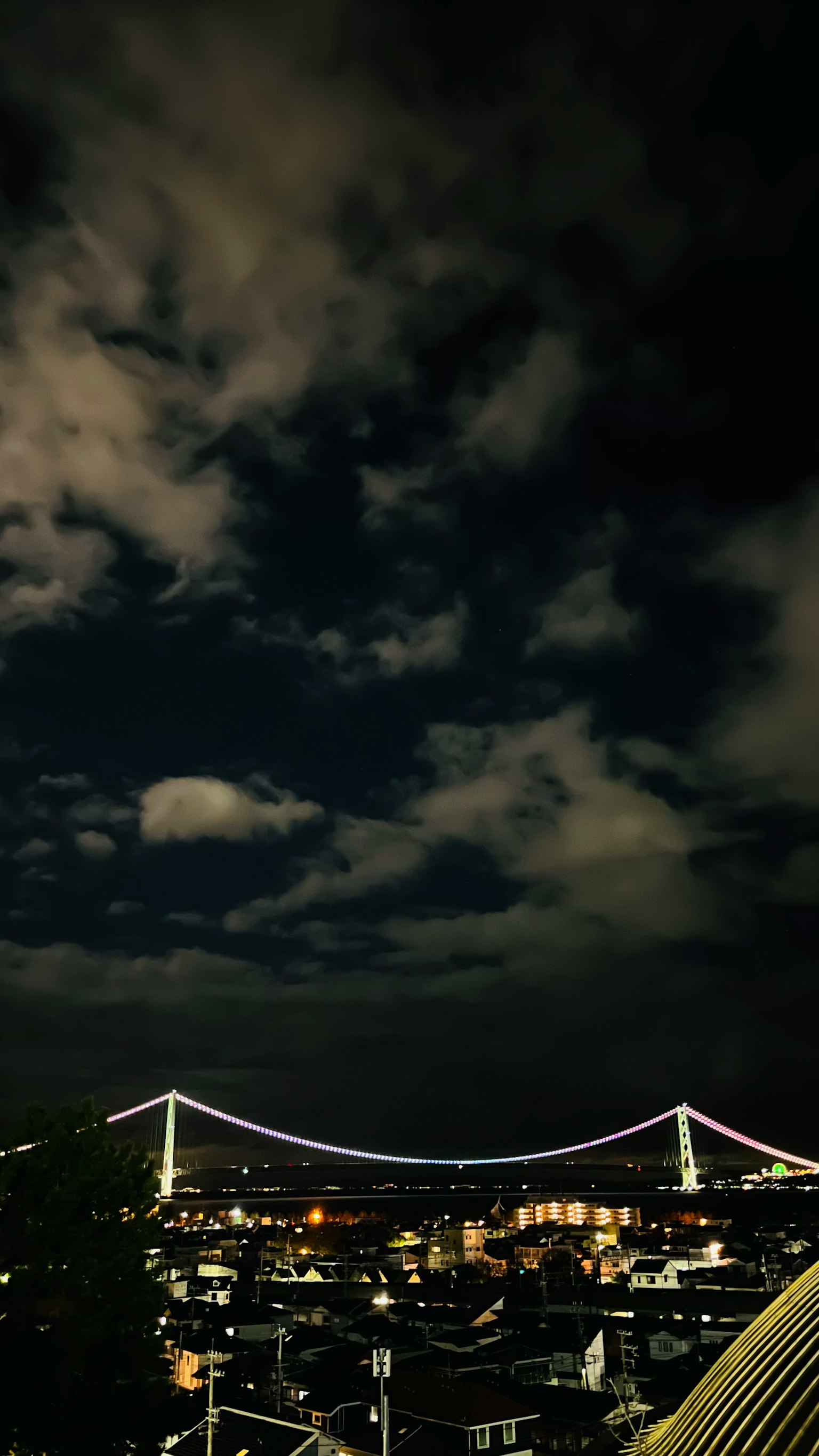 夜空中的云和灯光照亮的桥的景观