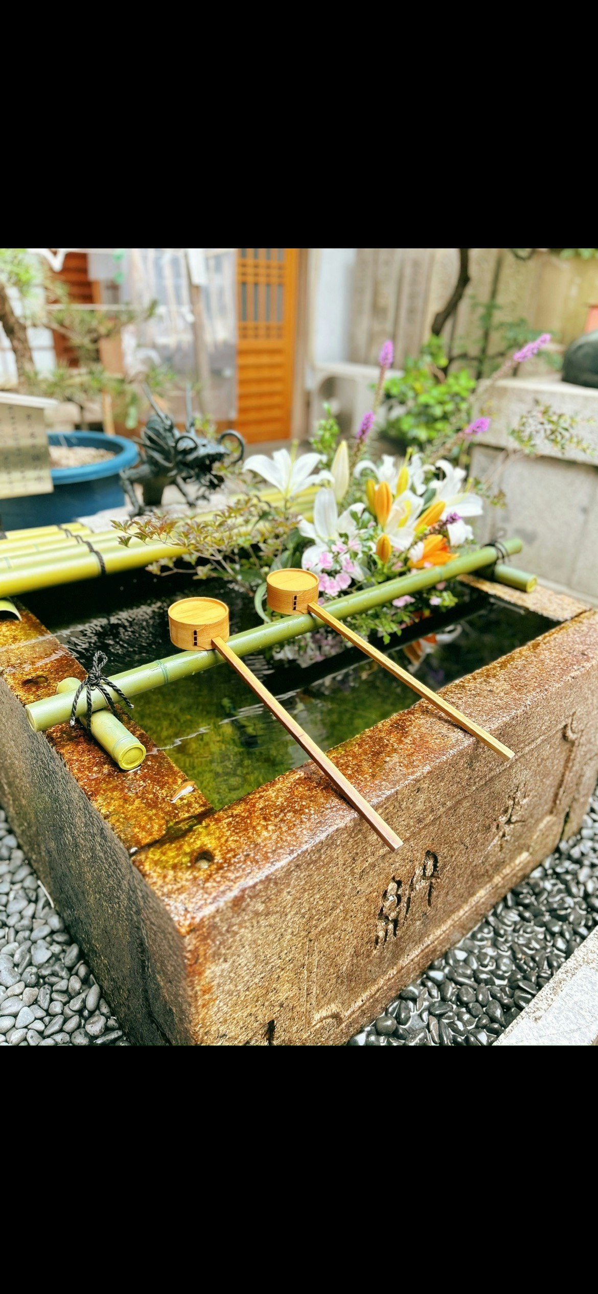 京都の路地にある手水鉢と花の飾り