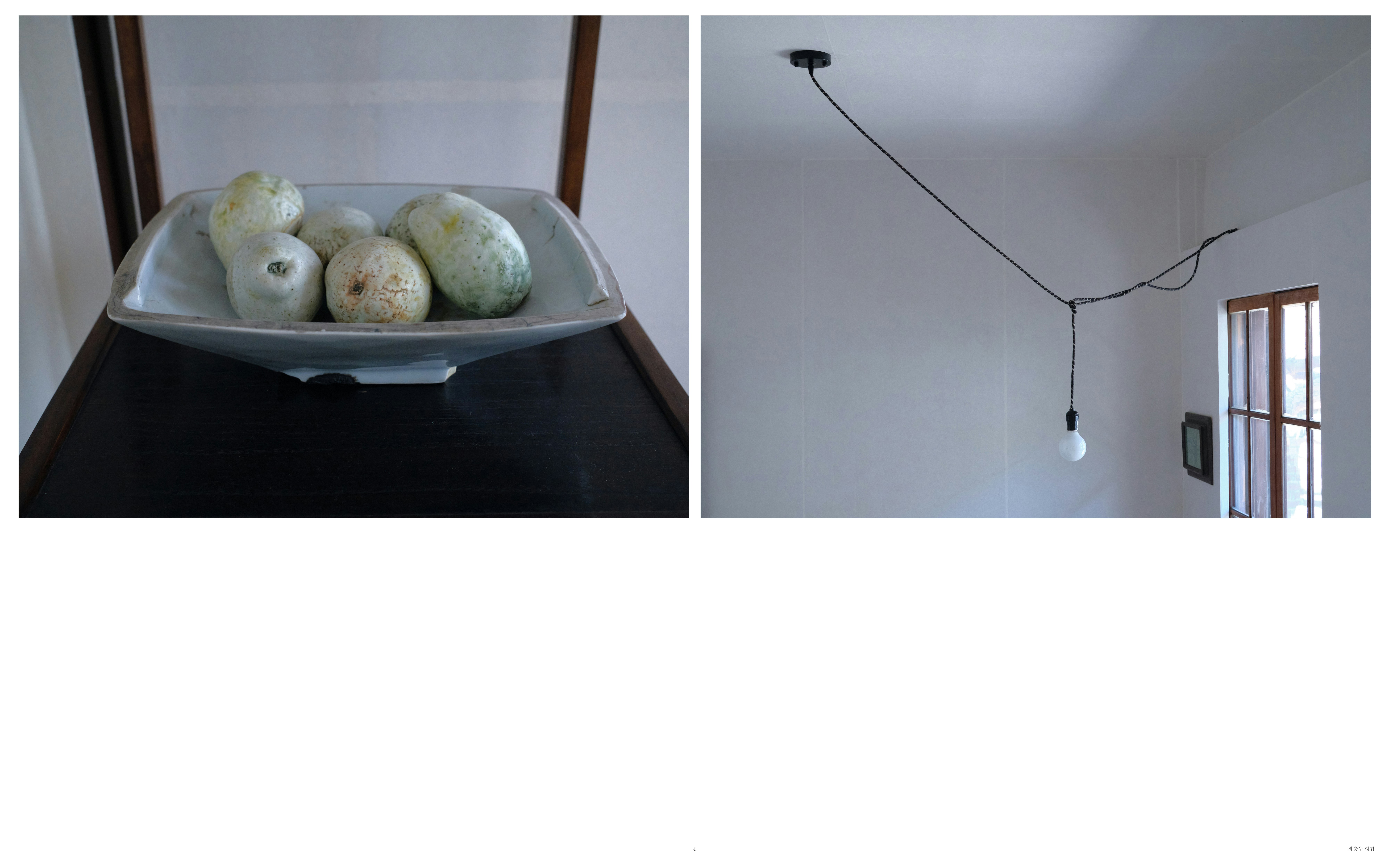 白い壁の部屋に置かれた果物の皿と天井からぶら下がる電球