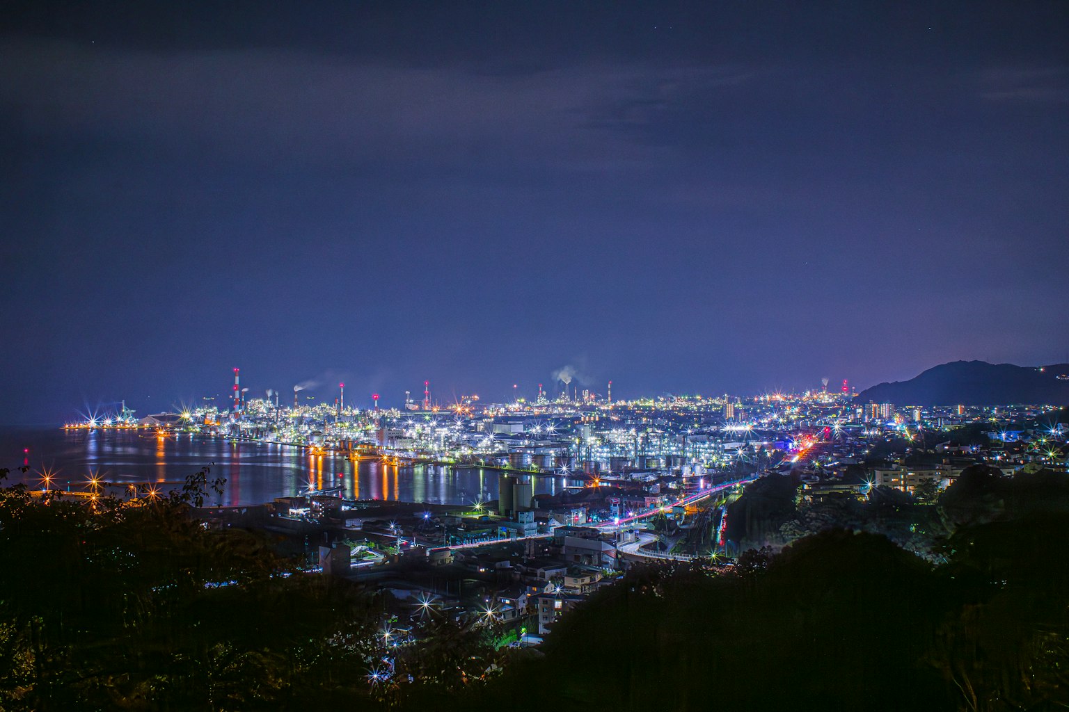 夜晚港口城市的全景明亮的灯光在水面上反射