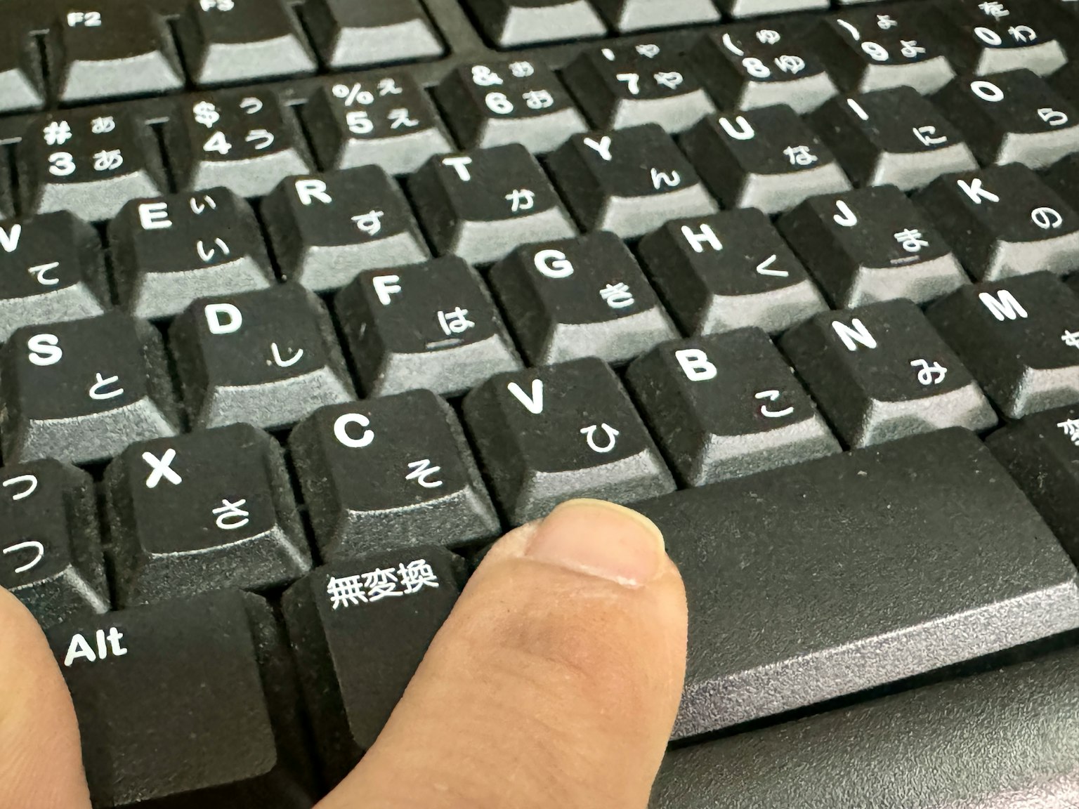 Nahaufnahme eines Fingers auf einer schwarzen Tastaturtaste