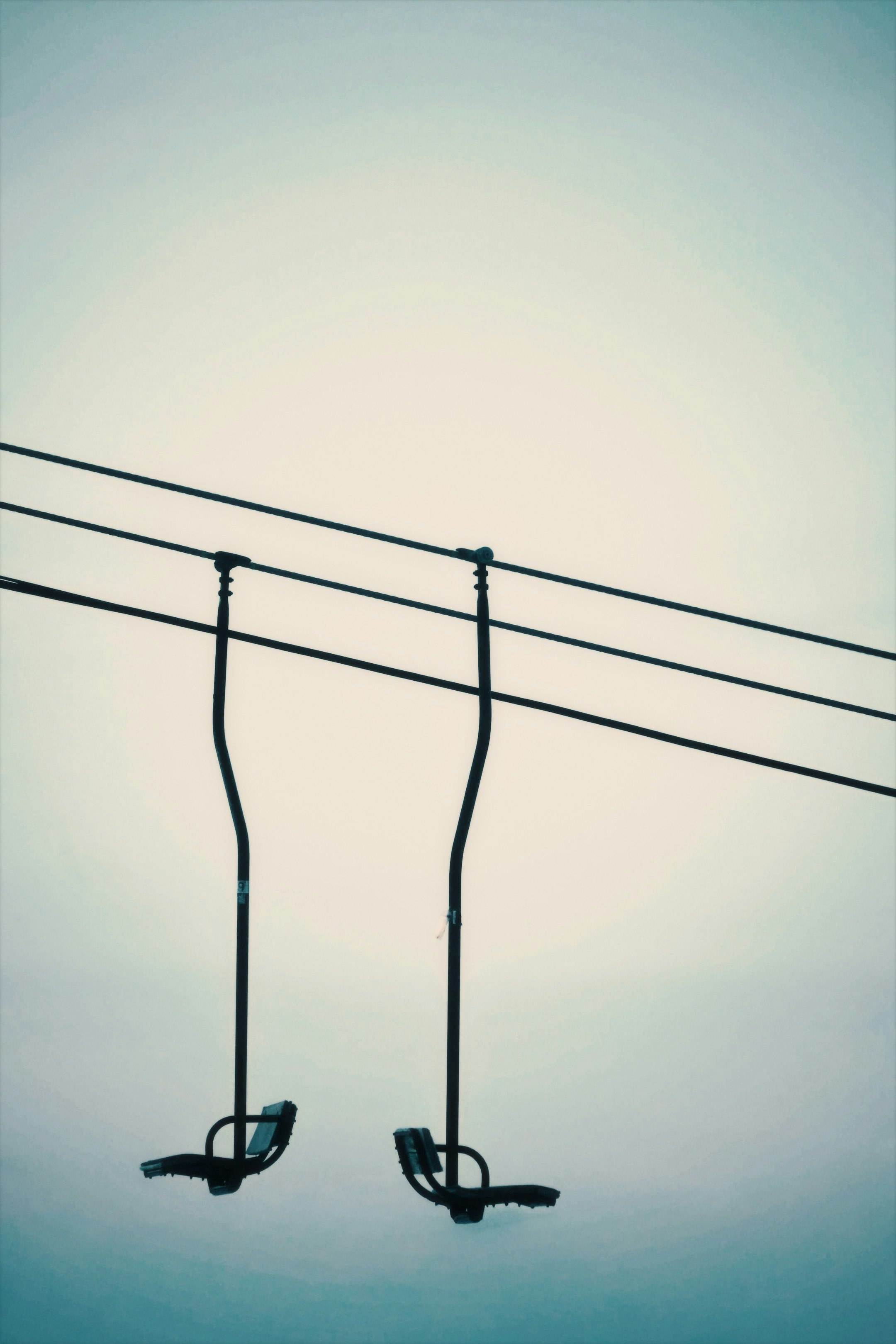Dos ganchos colgantes de cables contra el cielo