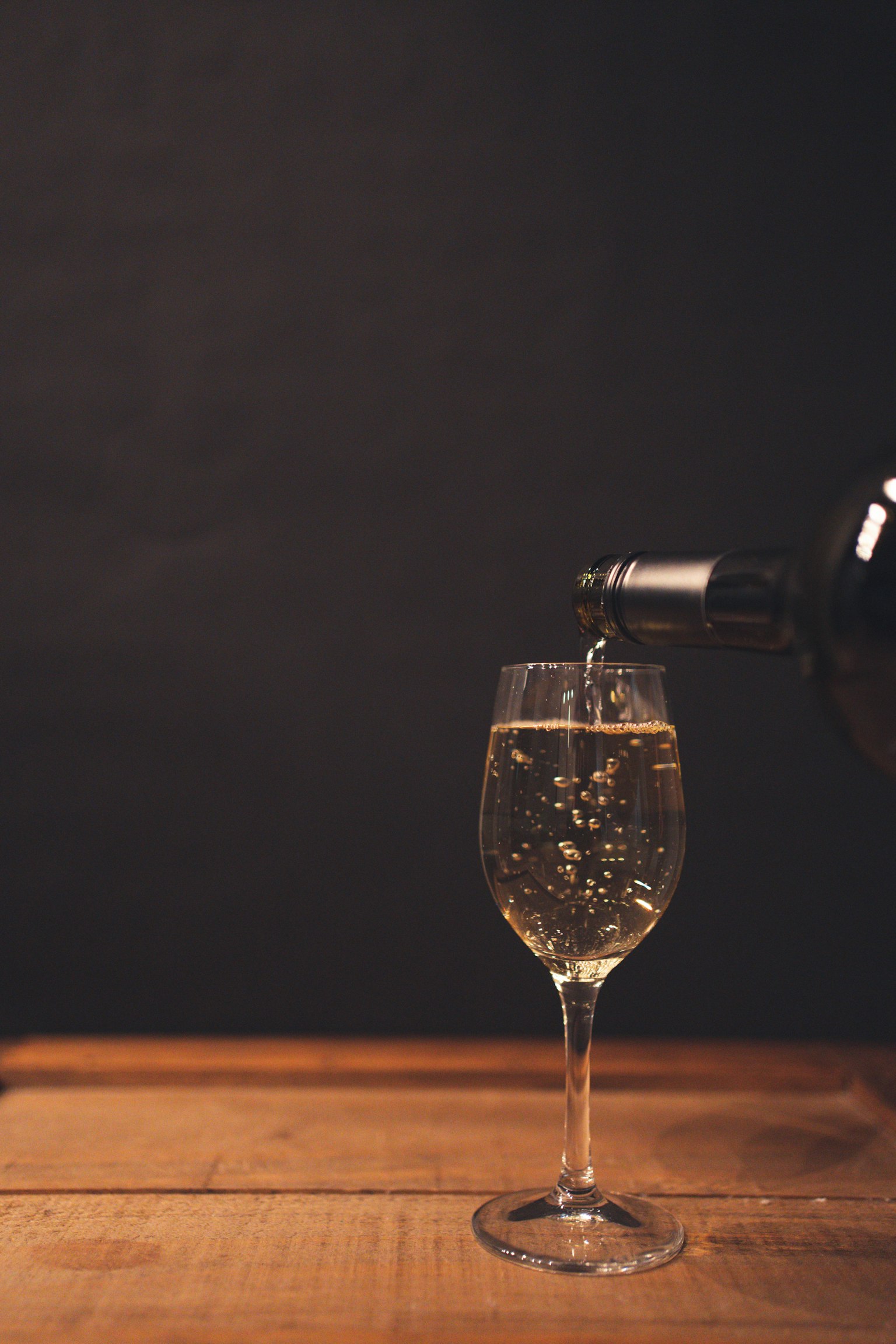 Un vino blanco espumoso siendo vertido en una copa
