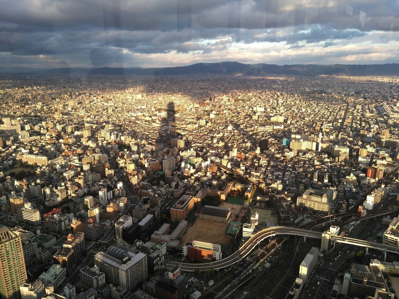 Vista aerea di un paesaggio urbano vasto con grattacieli e cielo nuvoloso