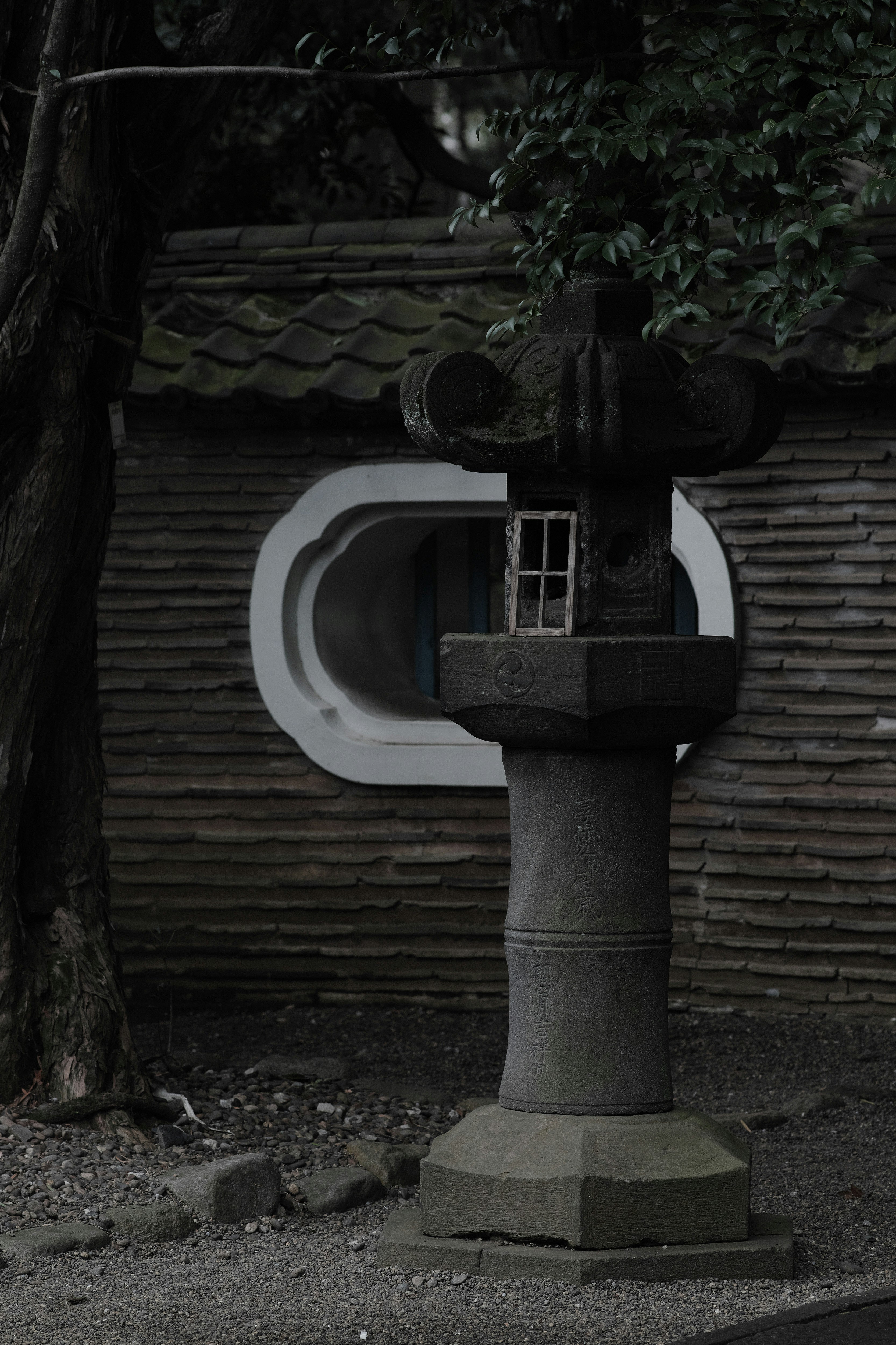 fuente de piedra junto a un ishidoro en un santuario
