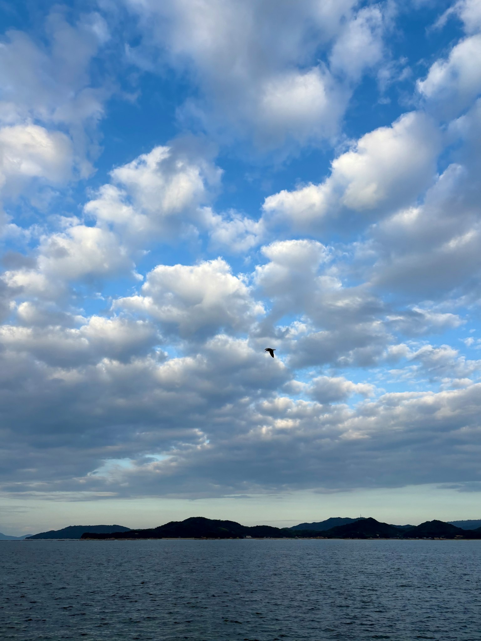 青い空と白い雲が広がる海の風景 島々が遠くに見える