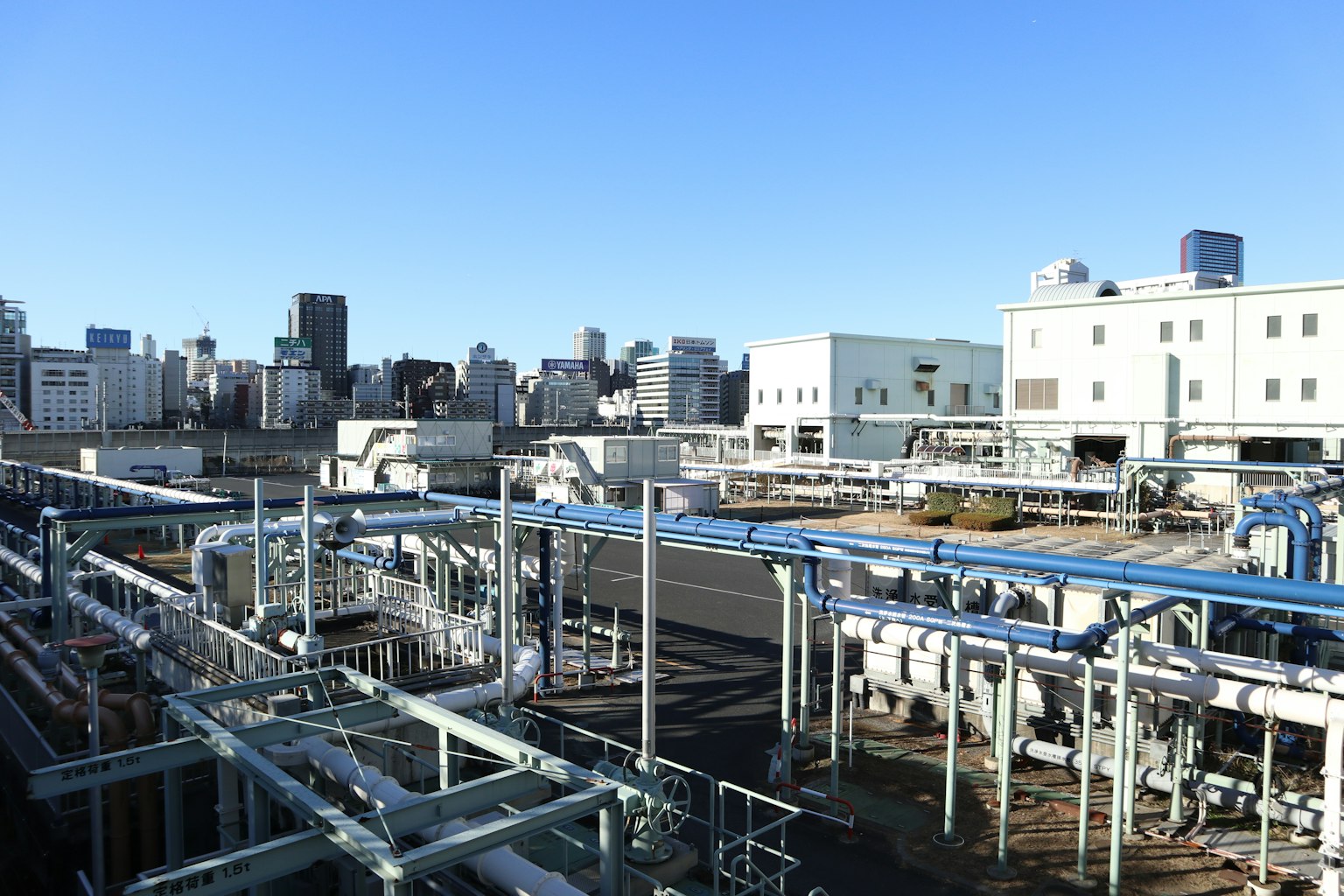 Vue depuis le toit d'une installation industrielle montrant des équipements et des tuyaux