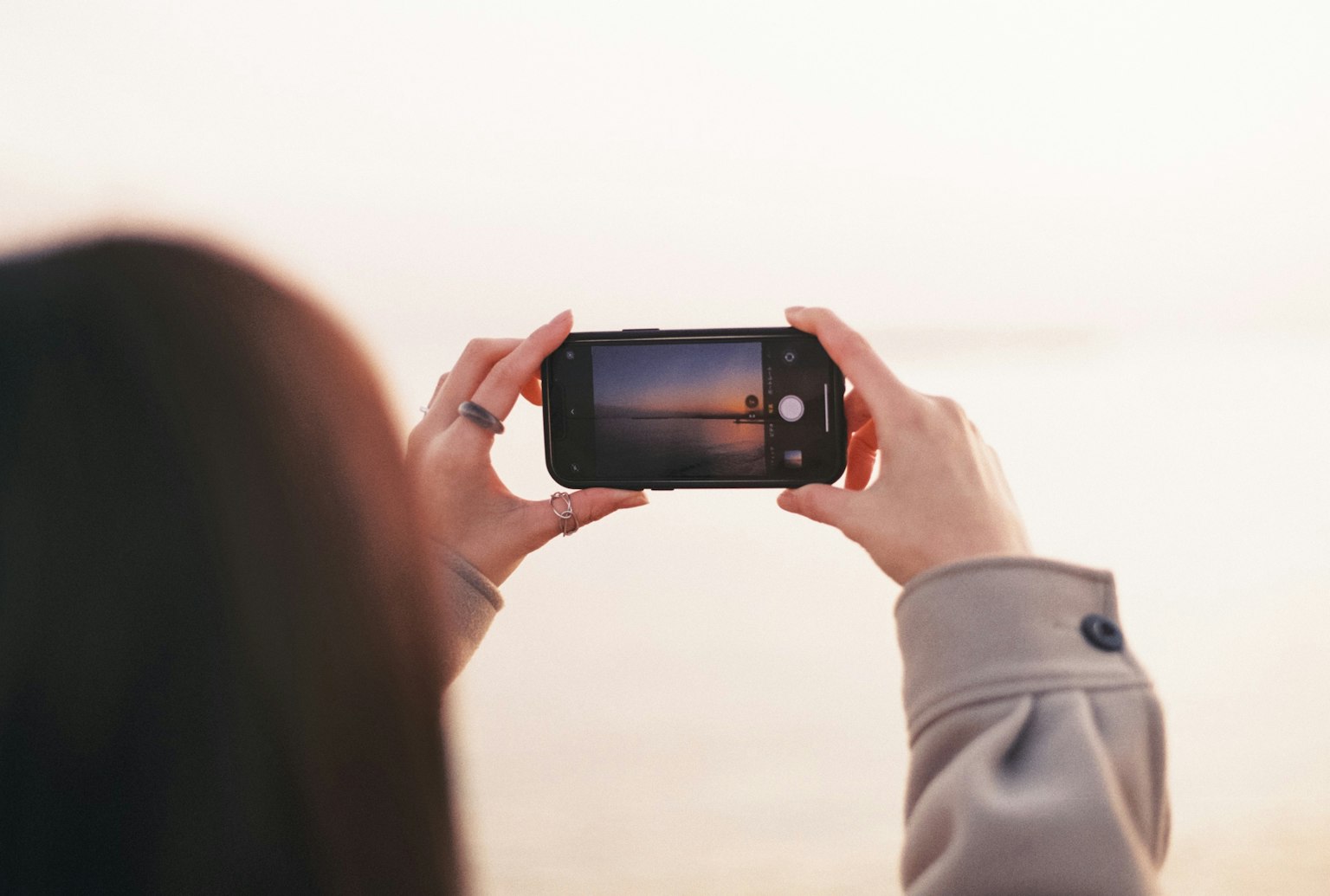 一名女性用智能手机拍摄风景