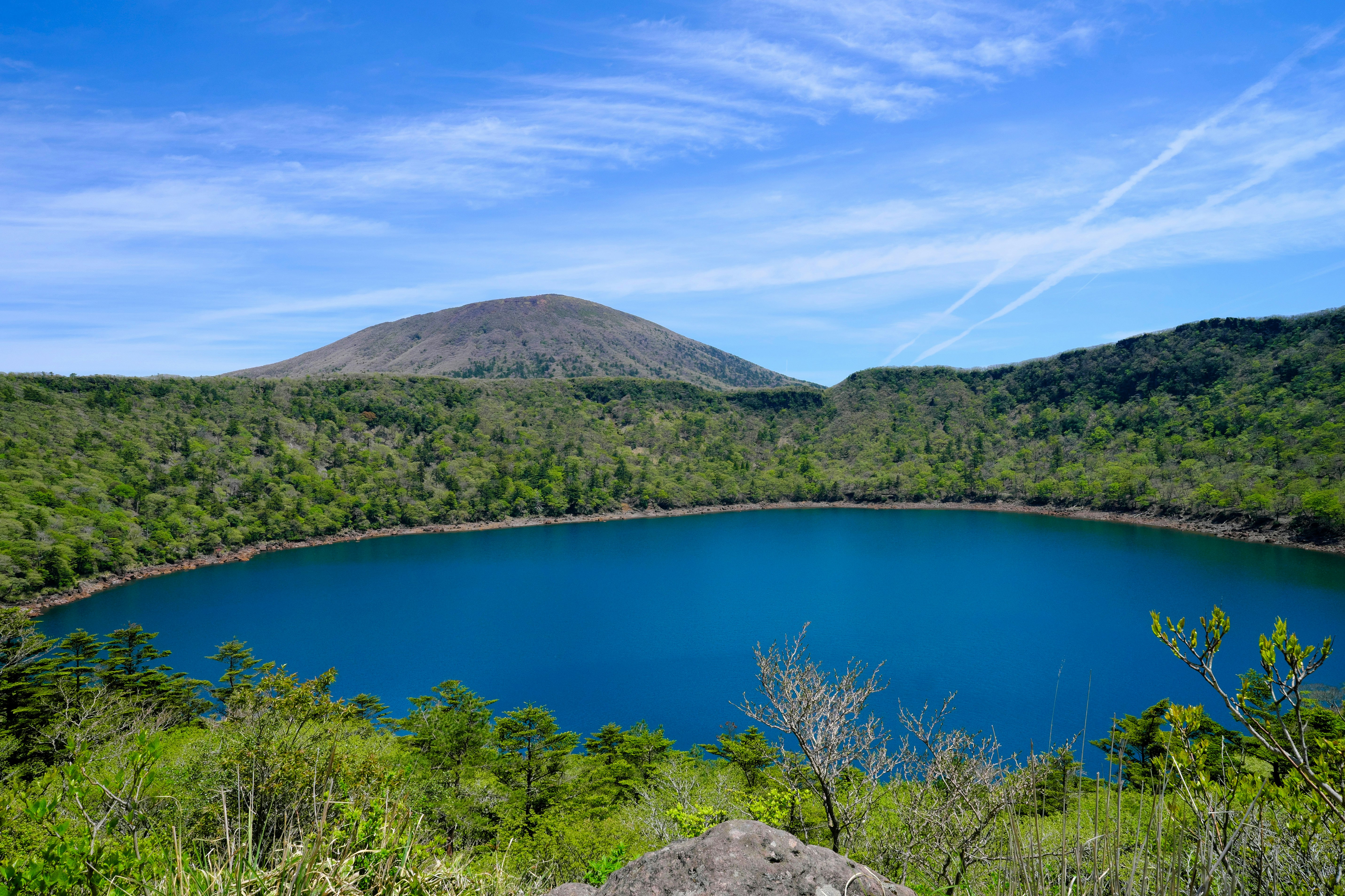 緑の森に囲まれた火山の湖の風景