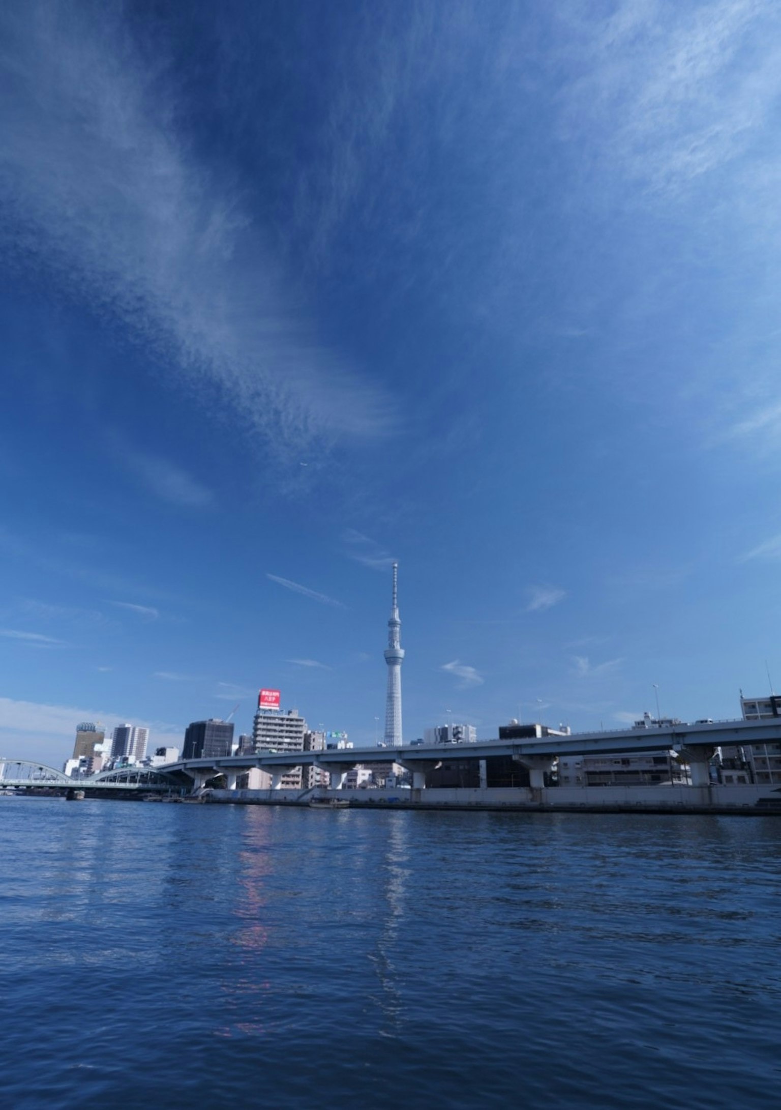 Tokyo Skytree berdiri di bawah langit biru dalam pemandangan Tokyo
