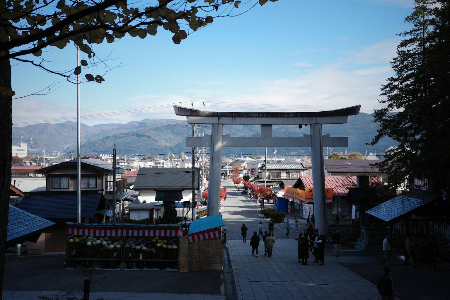 Vista escénica de una ciudad con un torii y montañas al fondo