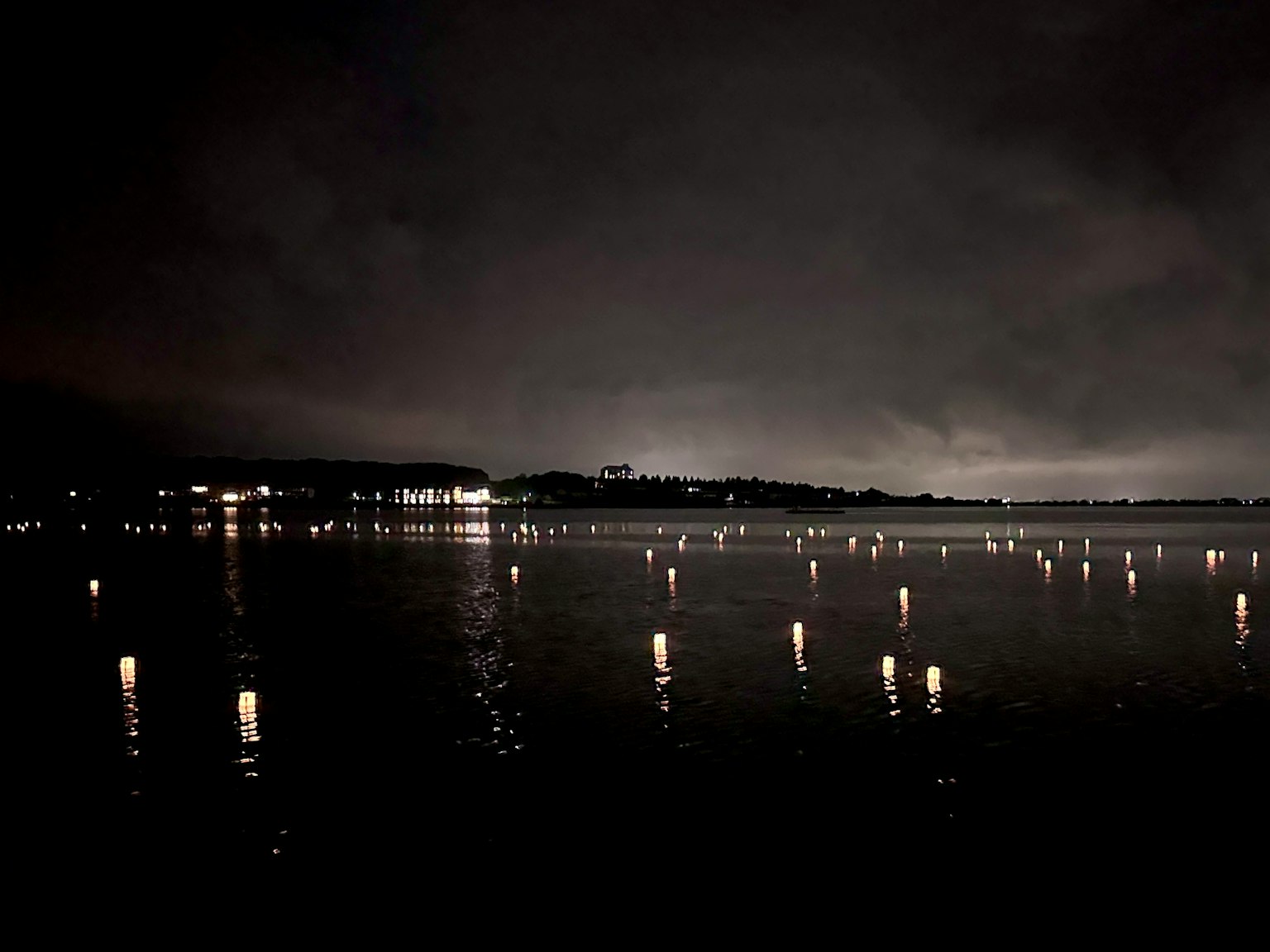 Vista notturna di un lago con riflessi di luci