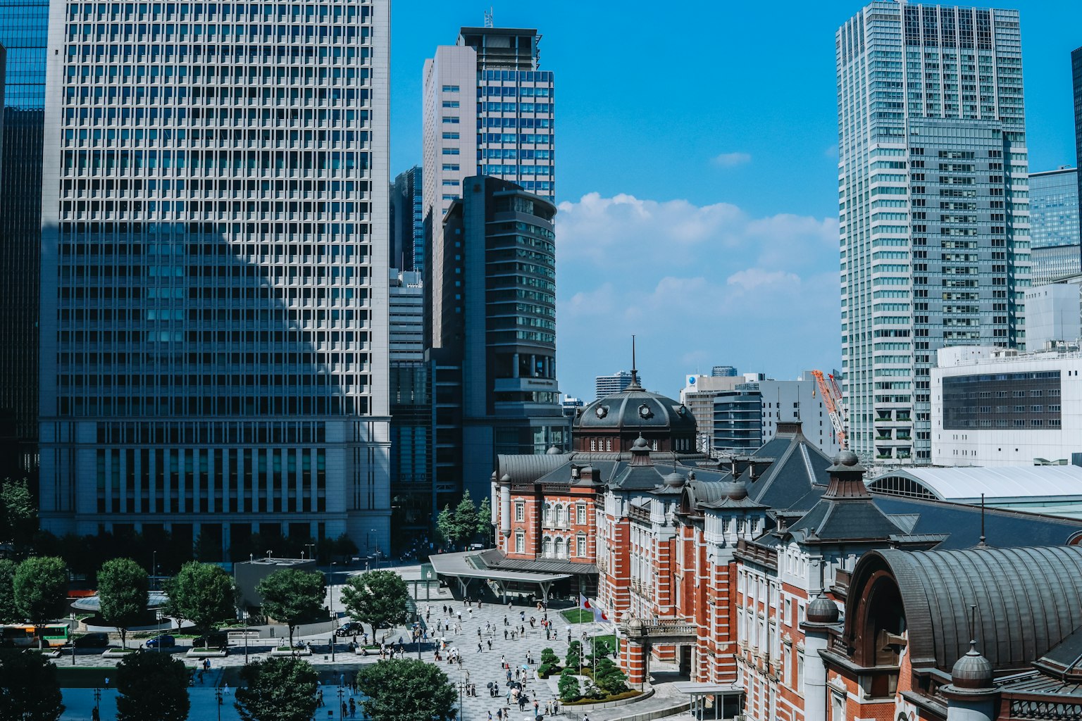 Cảnh ga Tokyo và các tòa nhà chọc trời dưới bầu trời xanh
