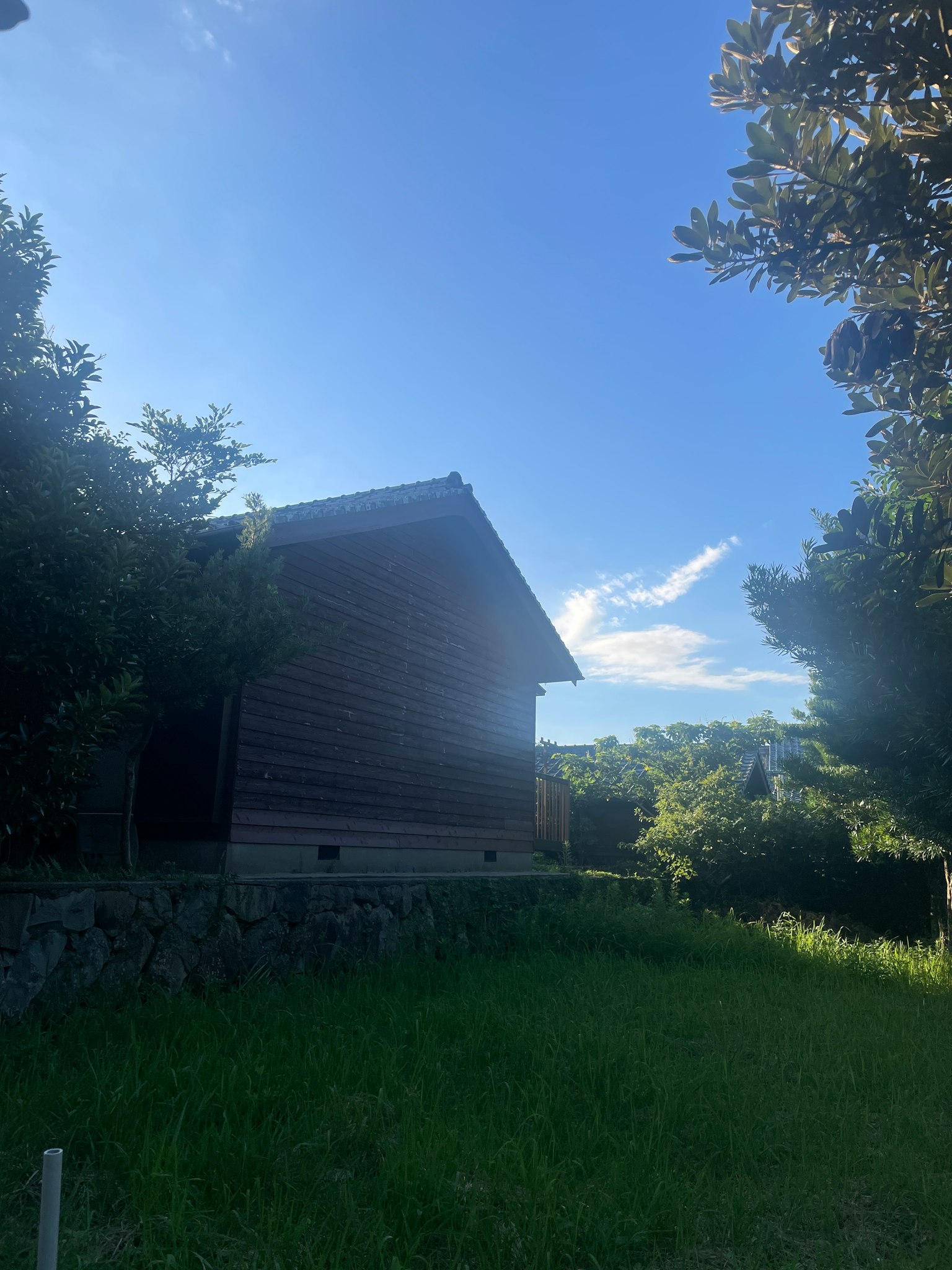 Holzhaus unter blauem Himmel mit grünem Gras