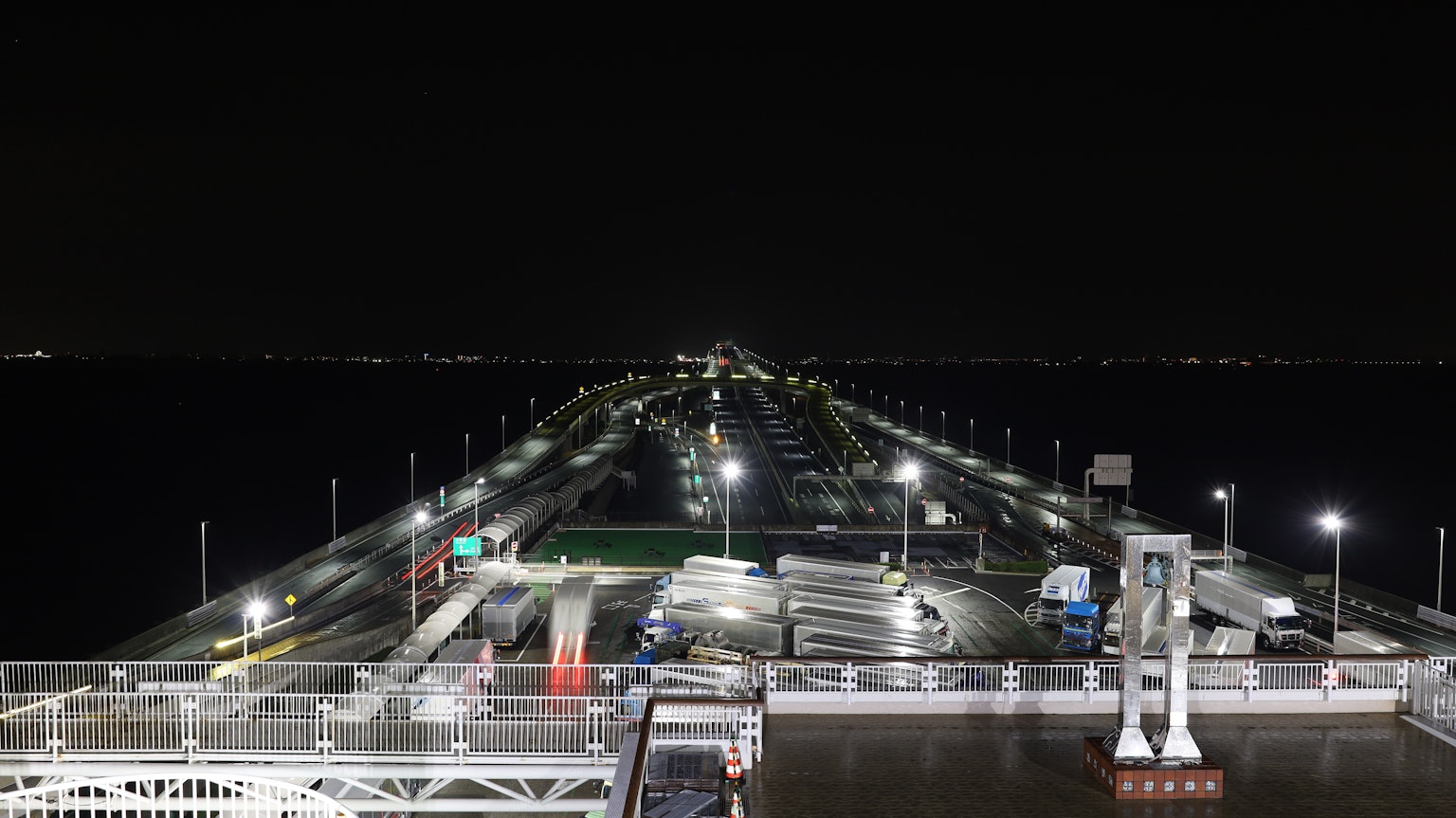 Beleuchteter Pier bei Nacht mit Blick auf das Wasser