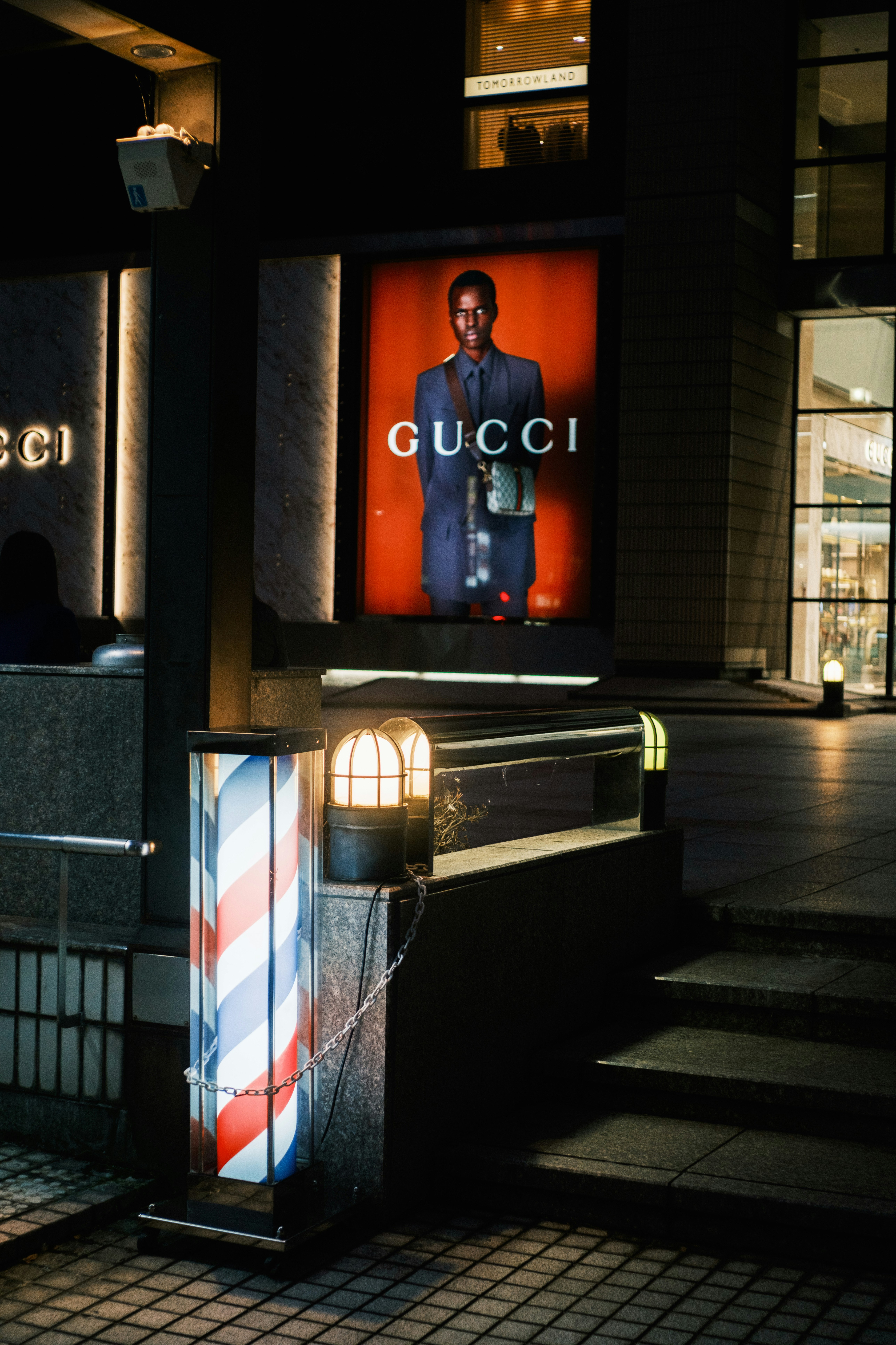 GUCCIの看板が灯る夜の路地の入口