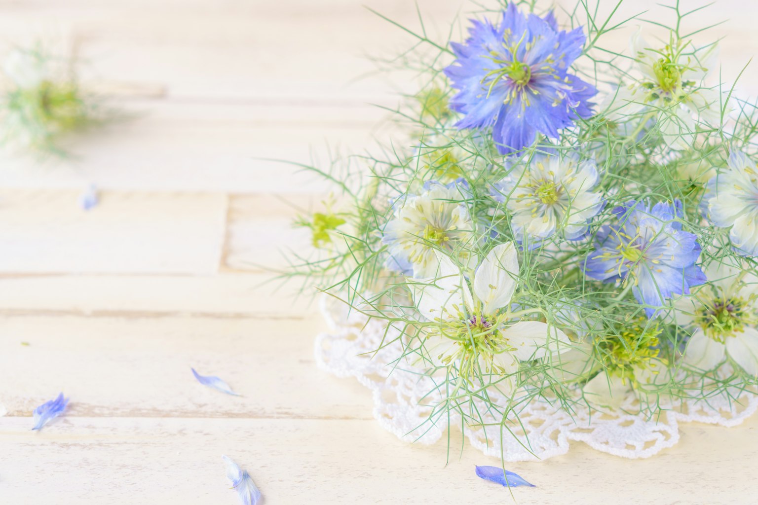 Arreglo de flores azules y blancas sobre una mesa de madera