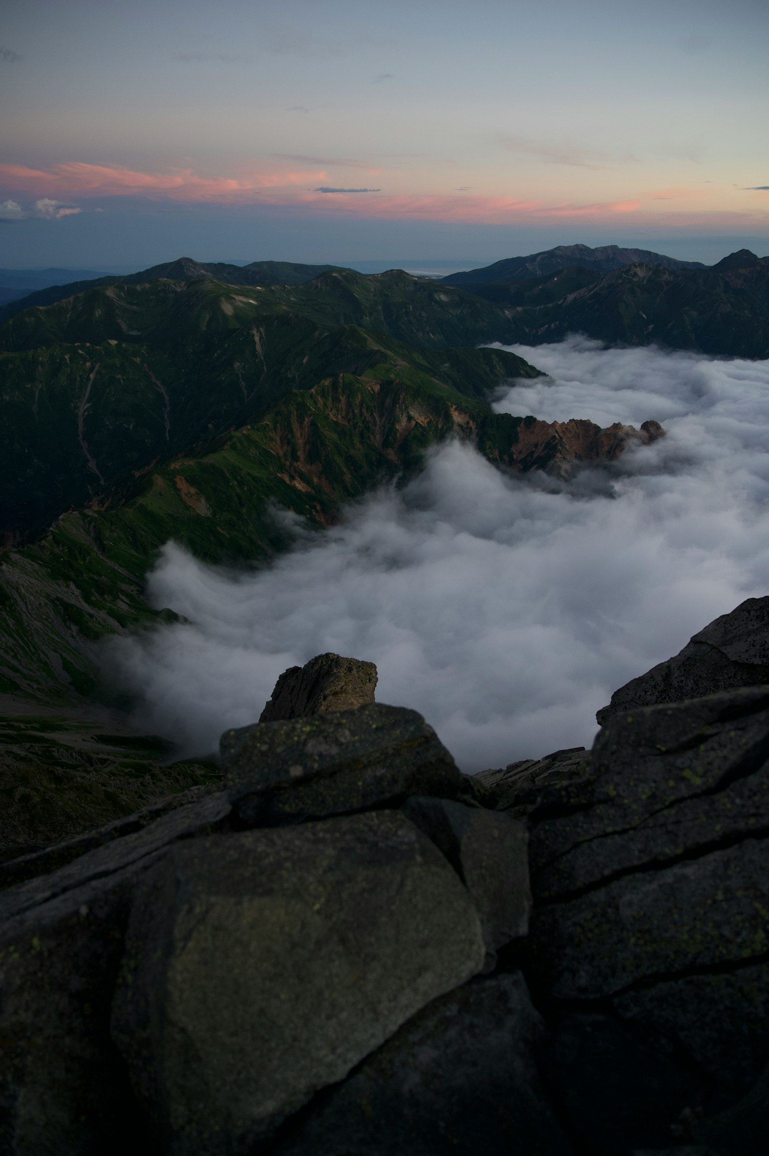 Vue d'une mer de nuages et du coucher de soleil depuis un sommet