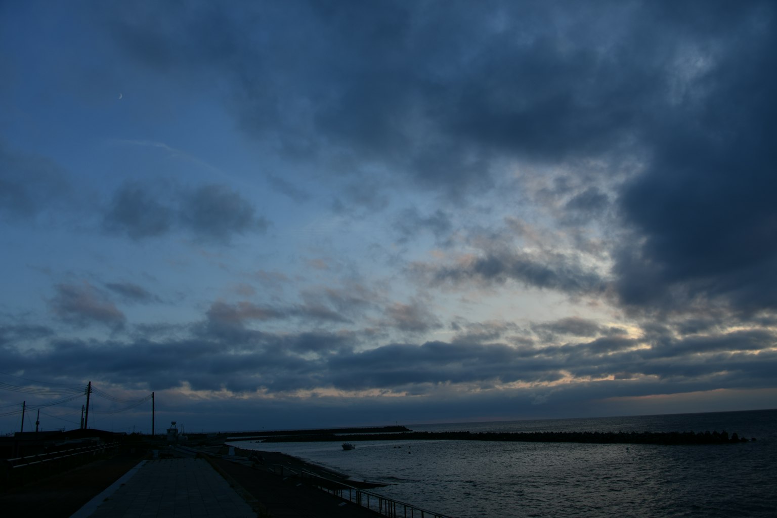 Cielo dramático con nubes oscuras sobre un mar tranquilo al atardecer