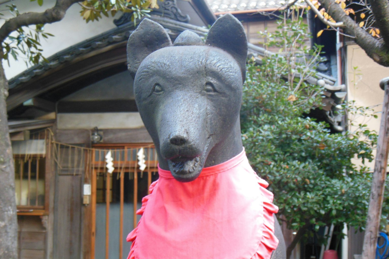 Escultura de perro negro con una bufanda roja