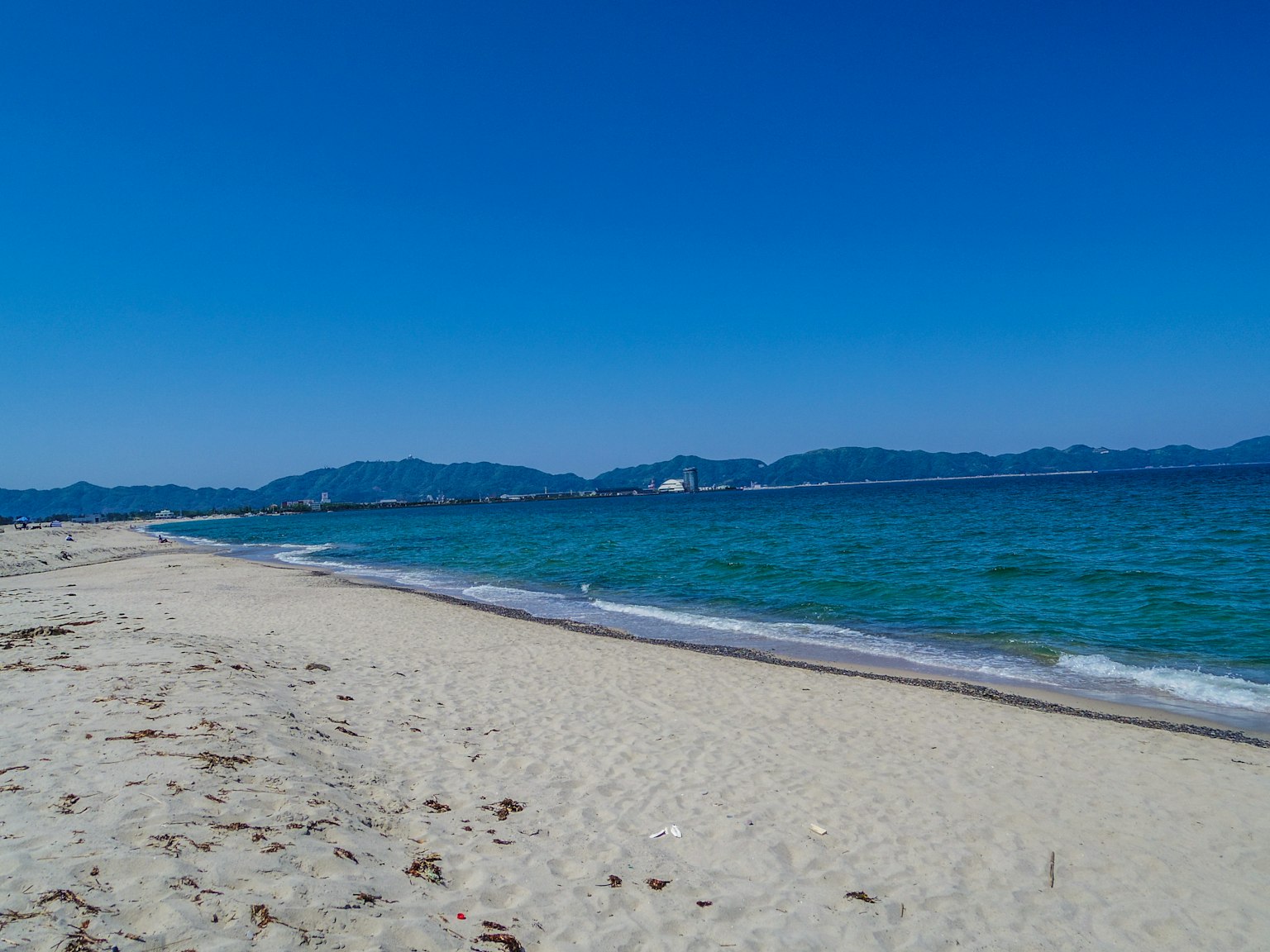 ภาพชายหาดที่มีท้องฟ้าสีฟ้าใสและทะเลสงบ
