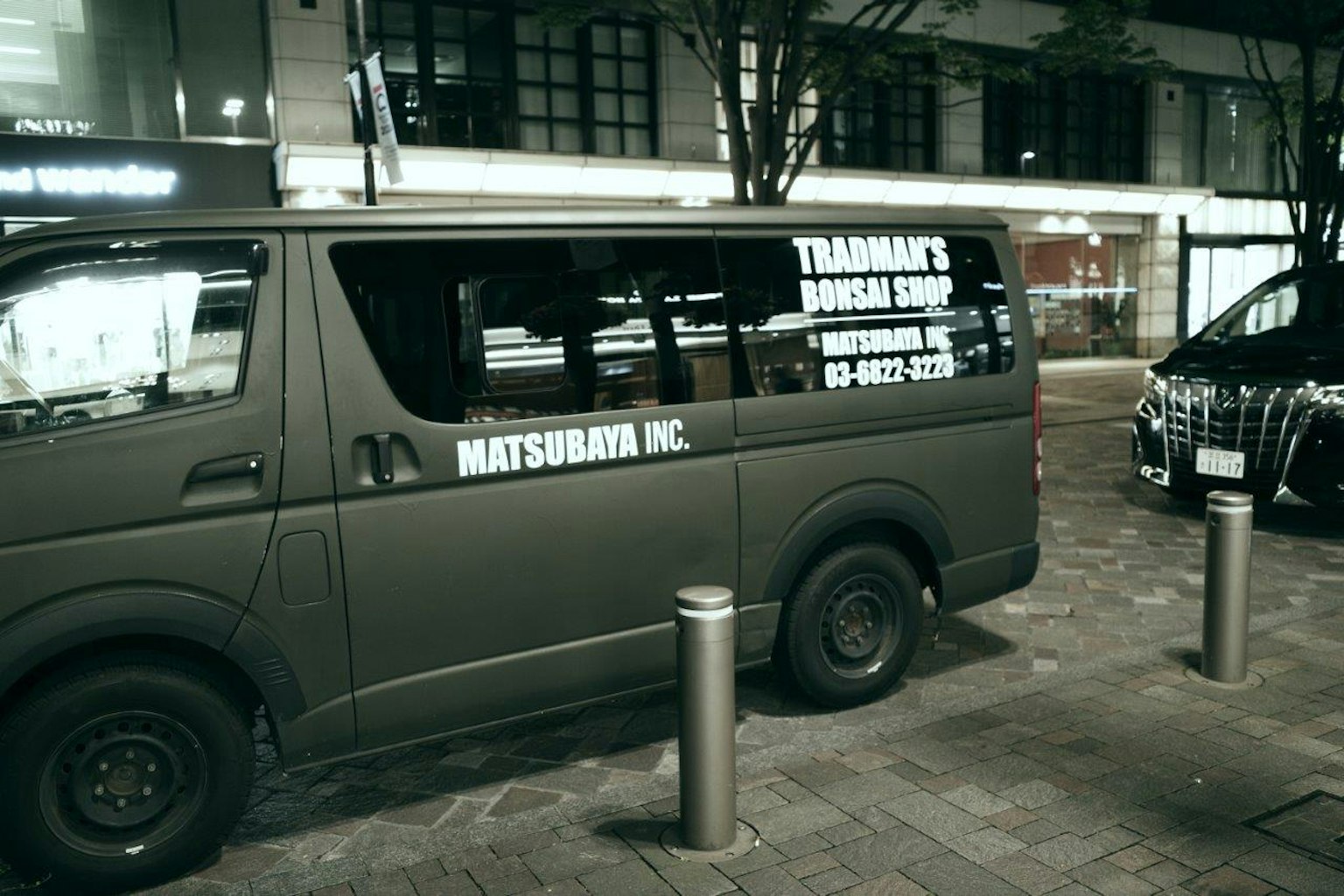 A parked minivan in a city at night featuring taxi service advertisement