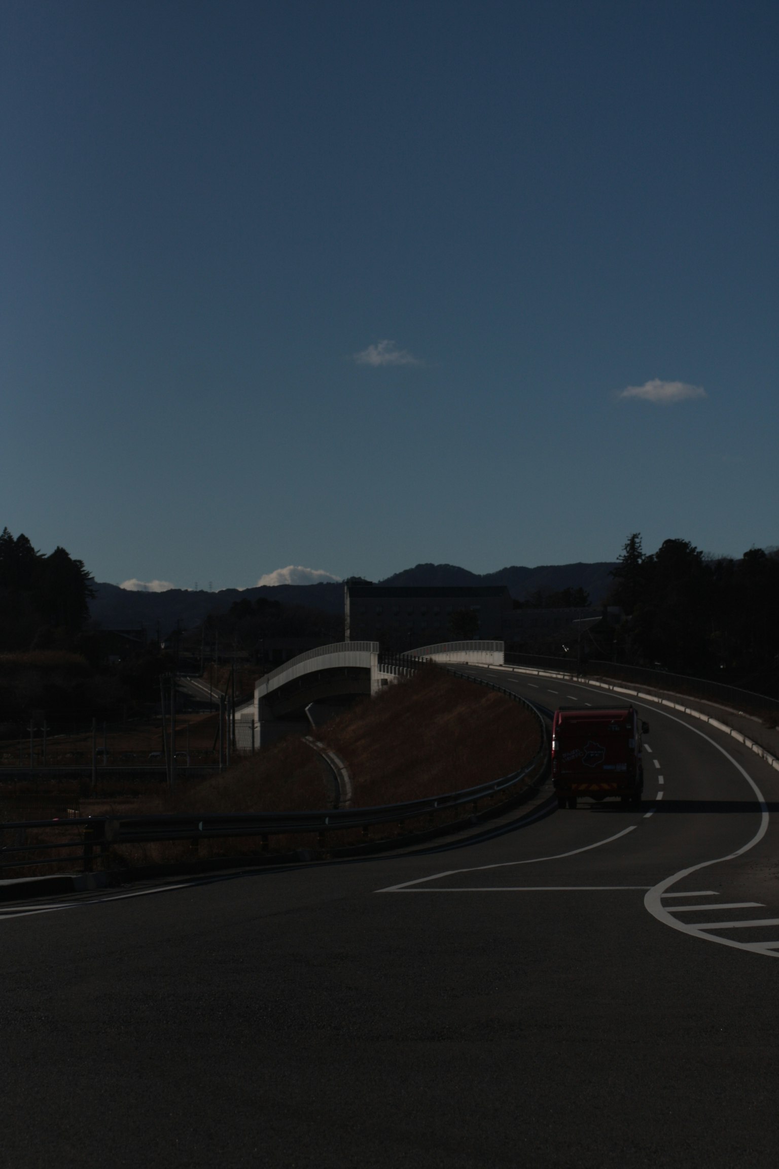 Kurvige Straße und Brücke unter einem dunklen Himmel
