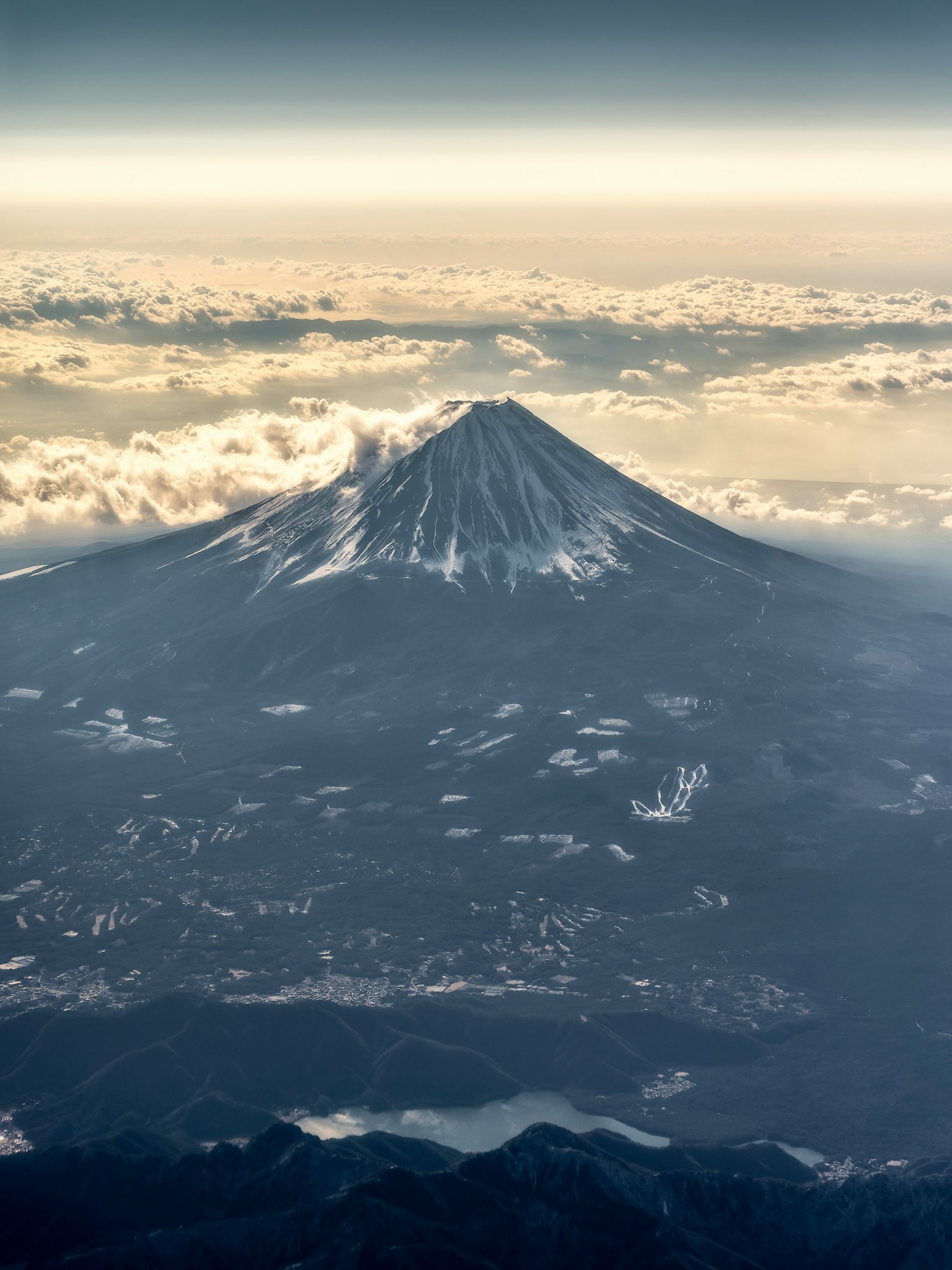 富士山的空中視圖被雲環繞，雪頂