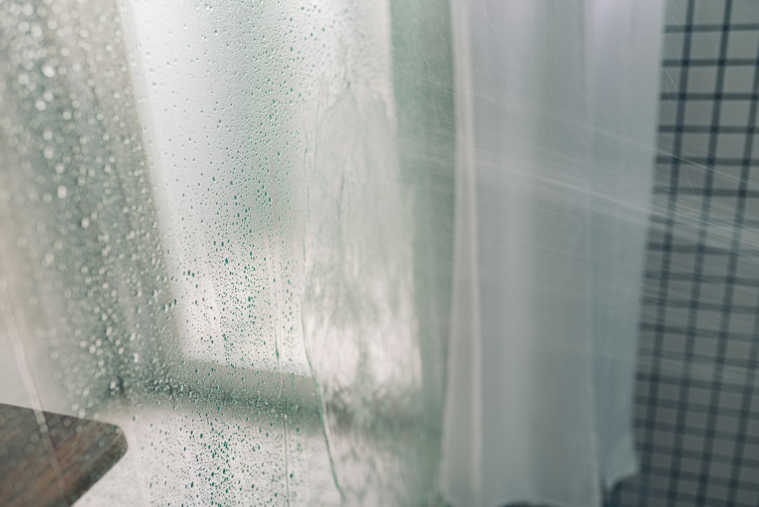 Scena di bagno con finestra appannata e tenda trasparente