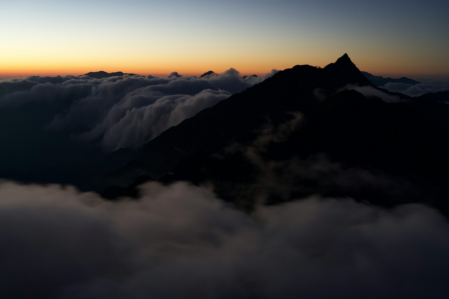 Silhouette de montañas sobre las nubes durante un hermoso atardecer
