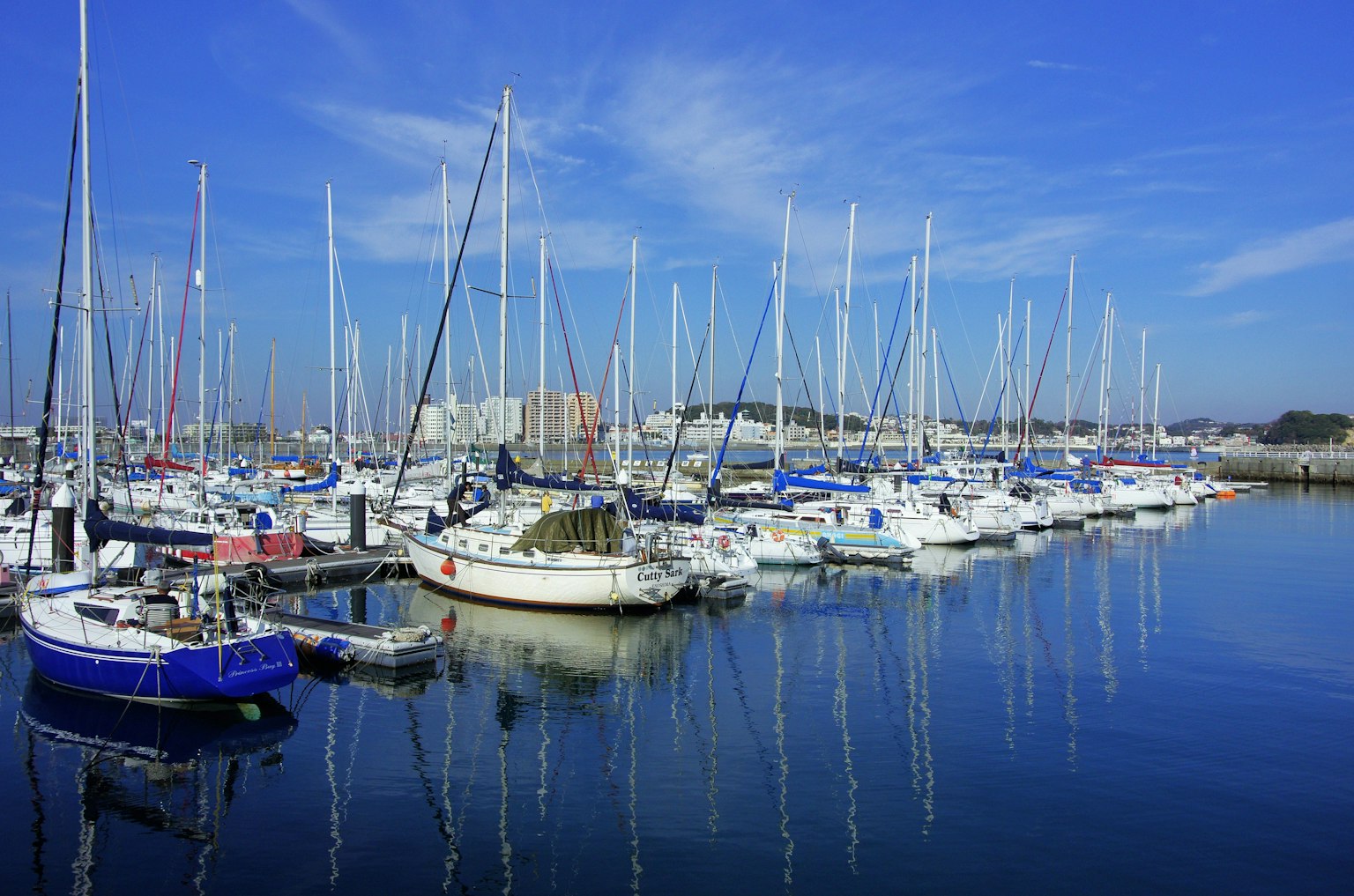 Un port pittoresque rempli de nombreux voiliers sous un ciel bleu