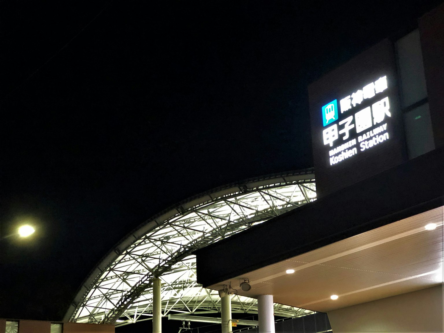 Nachtansicht des Schildes und des Daches der Station Koshien