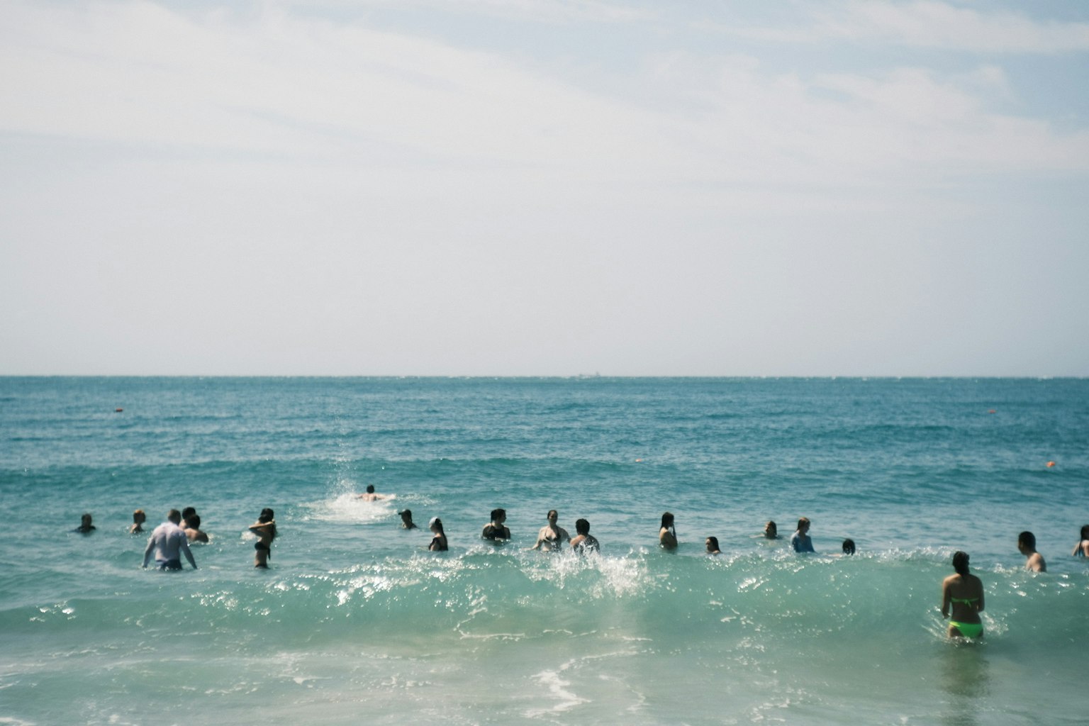 Groupe de personnes nageant dans l'océan avec de l'eau bleue et un ciel