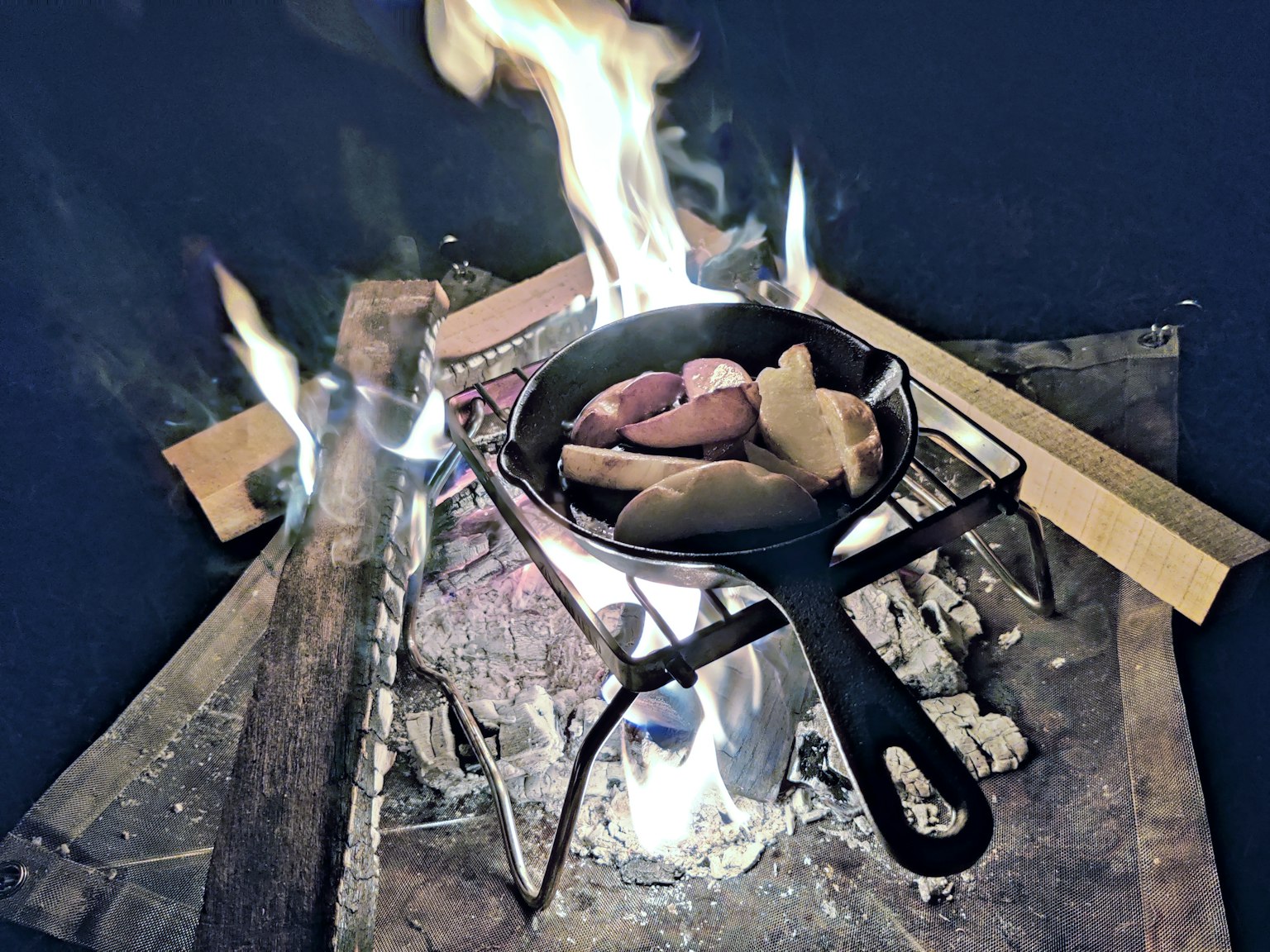 Berbagai bahan yang dimasak dalam wajan di atas api terbuka
