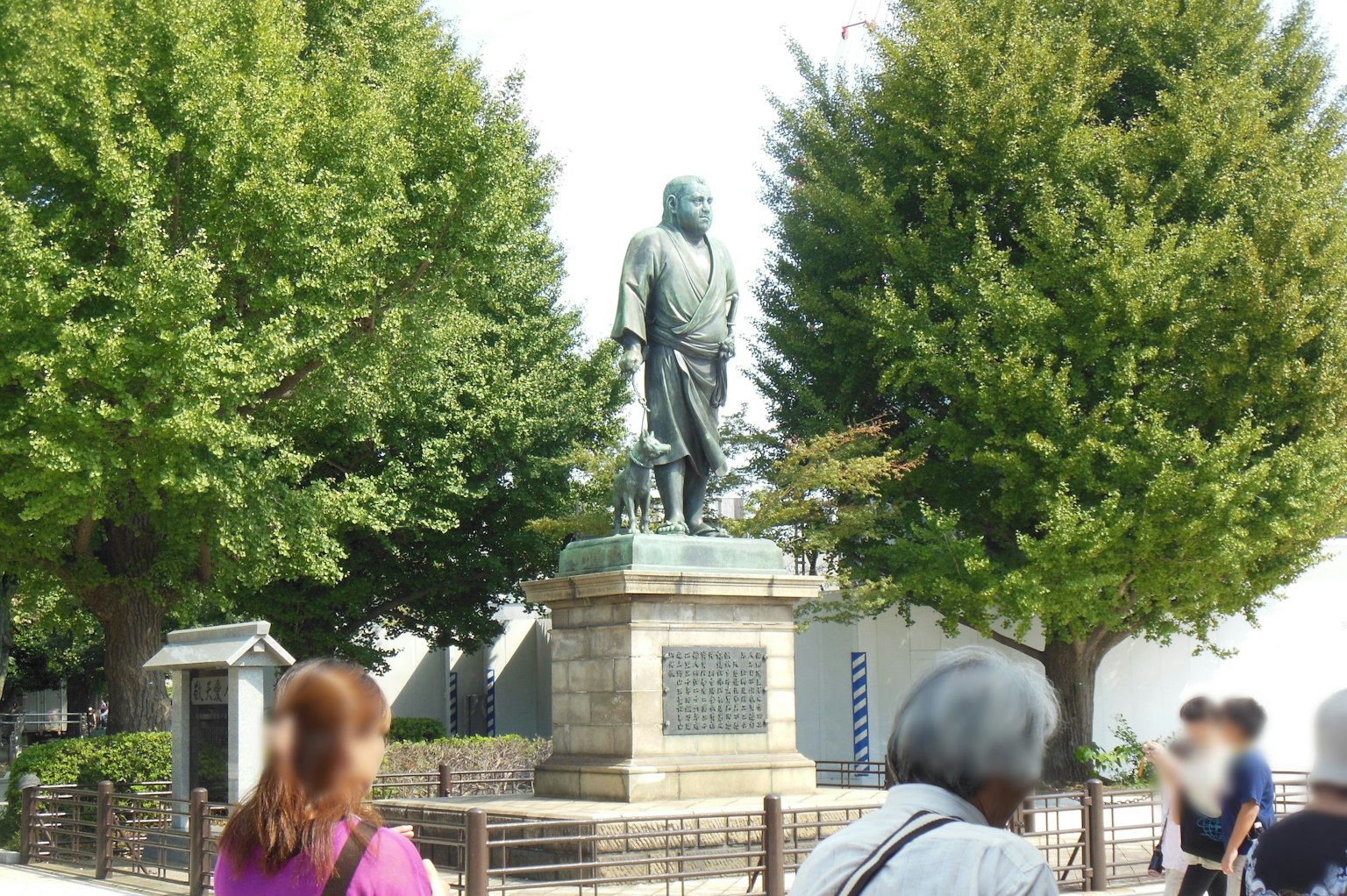 Image of a statue in a park with people gathered around it