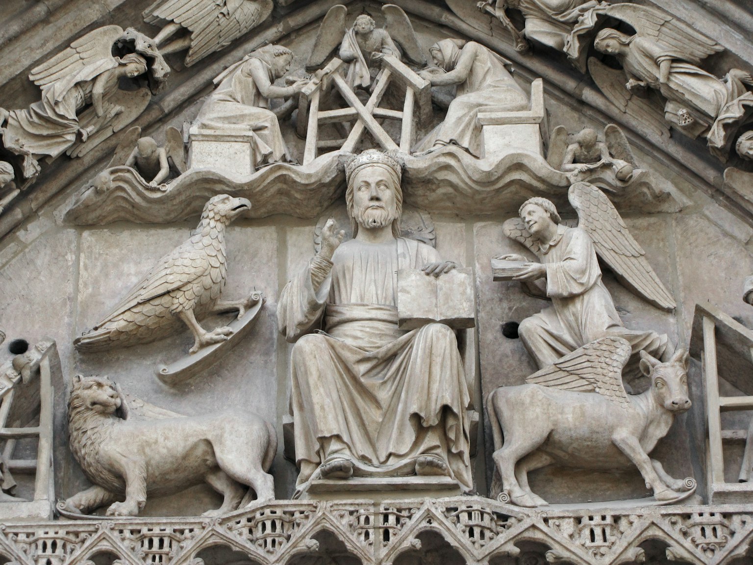 Figure sculptée de Jésus tenant une Bible avec des anges et des sculptures d'animaux autour