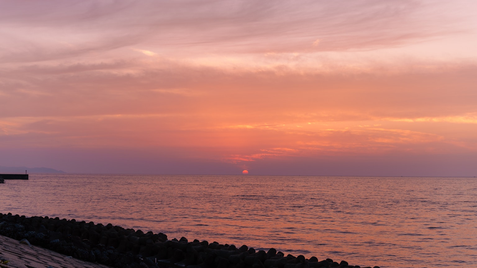 Sunset over the ocean with pink and orange sky