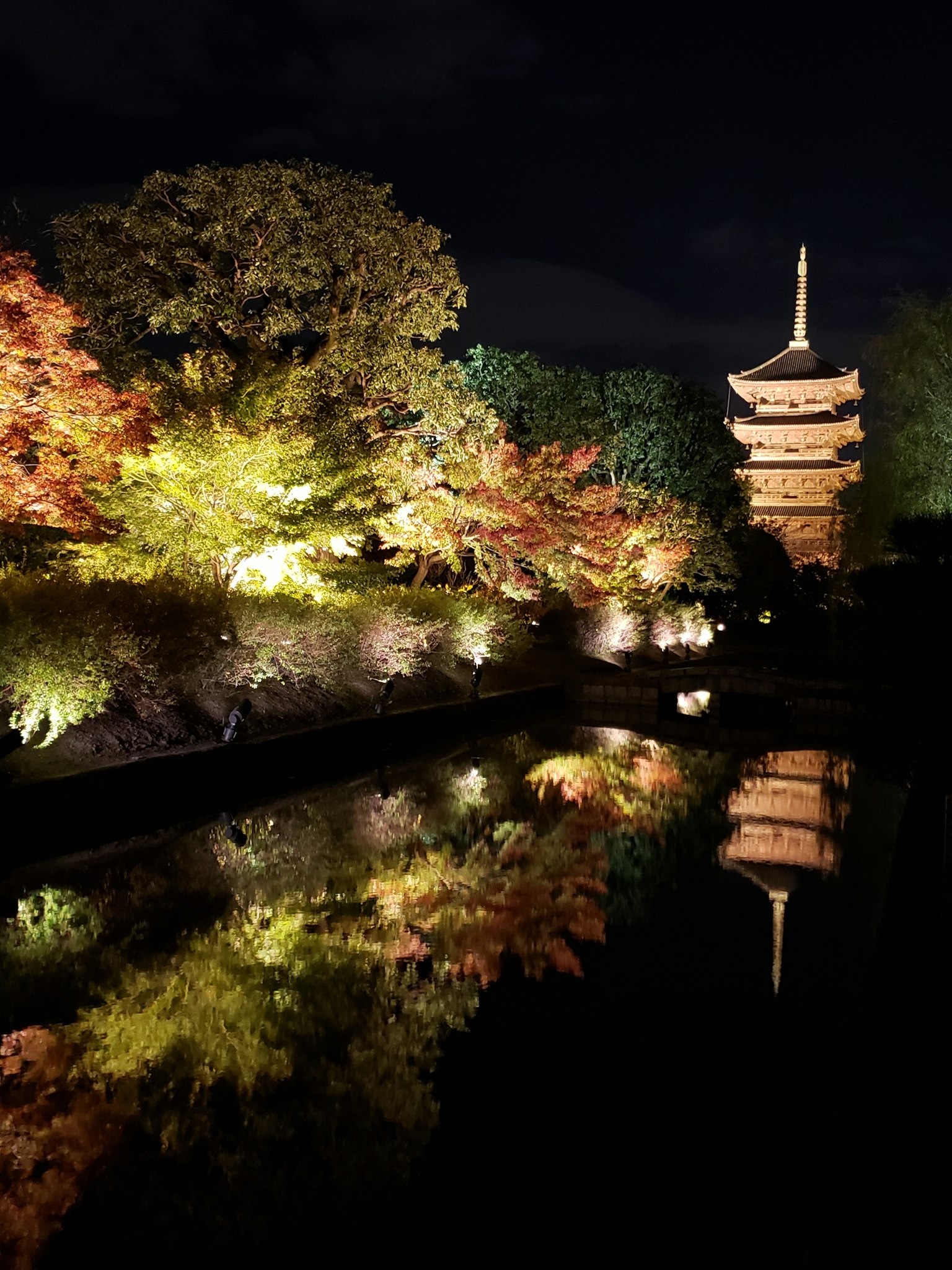 Belle pagode japonaise et feuilles d'automne reflétées dans un étang la nuit