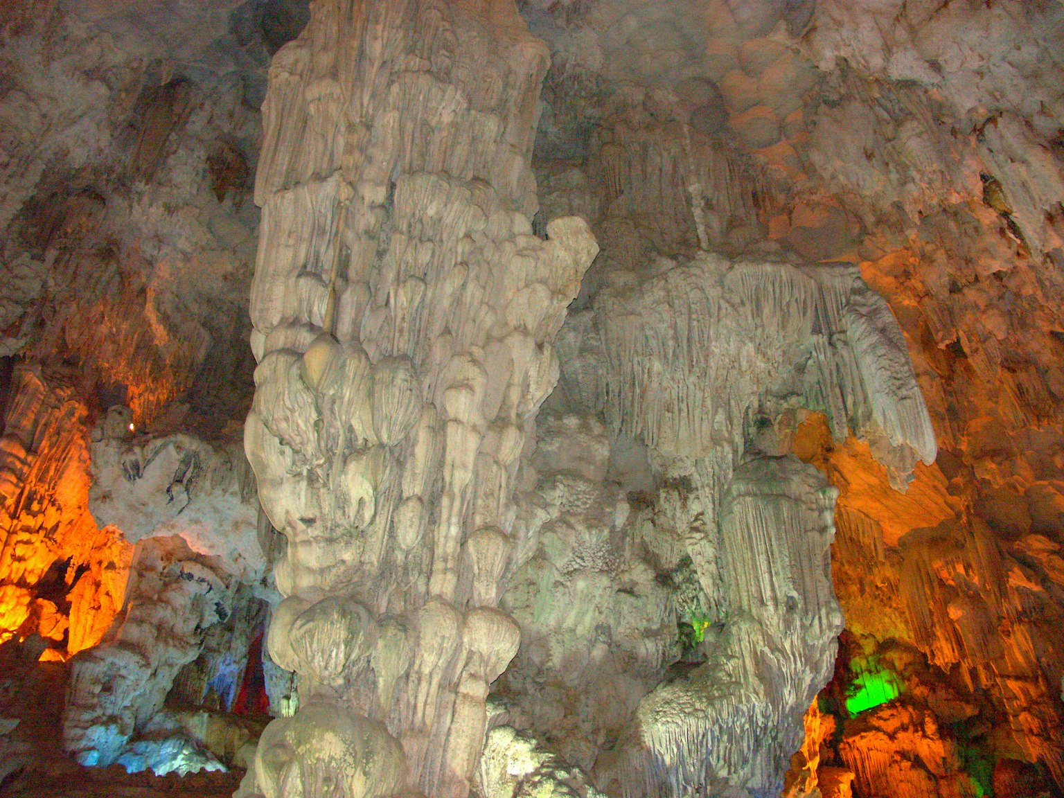 Große Steinsäulen in einer Höhle mit bunten Lichtern