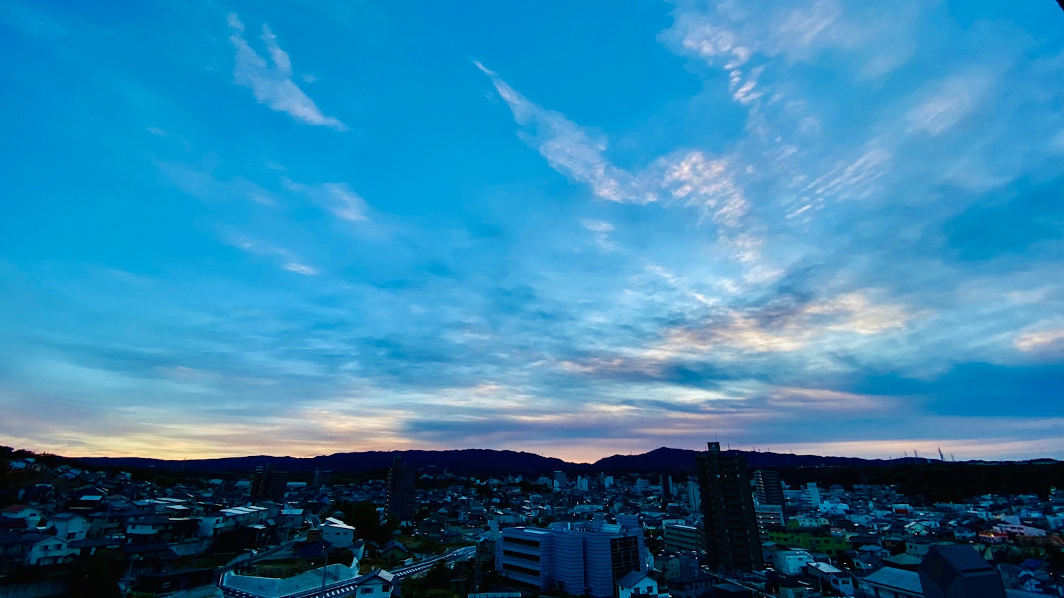 Vue panoramique d'un ciel bleu avec des nuages et un paysage urbain