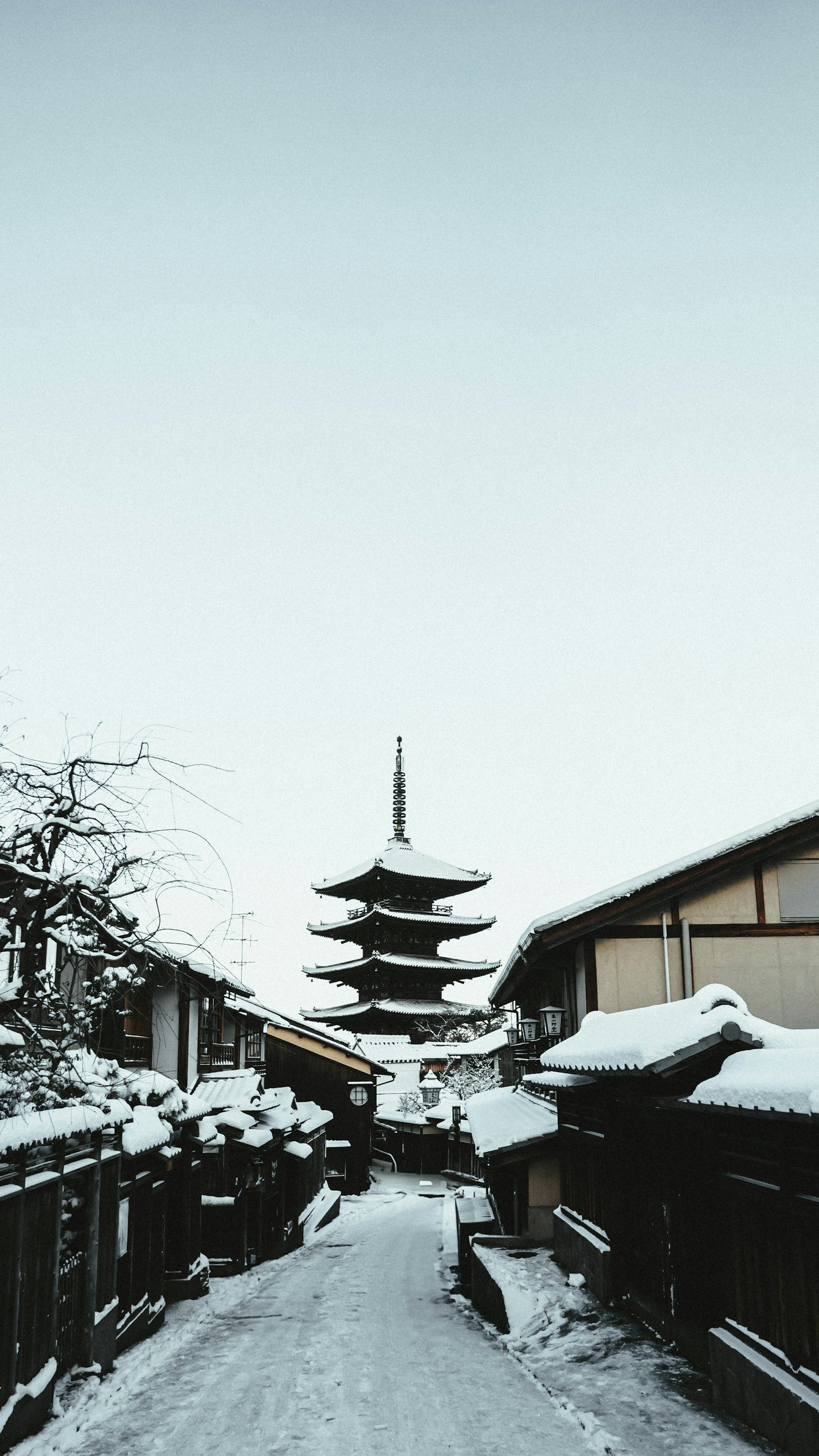 Snow-covered street scene with a pagoda in the background