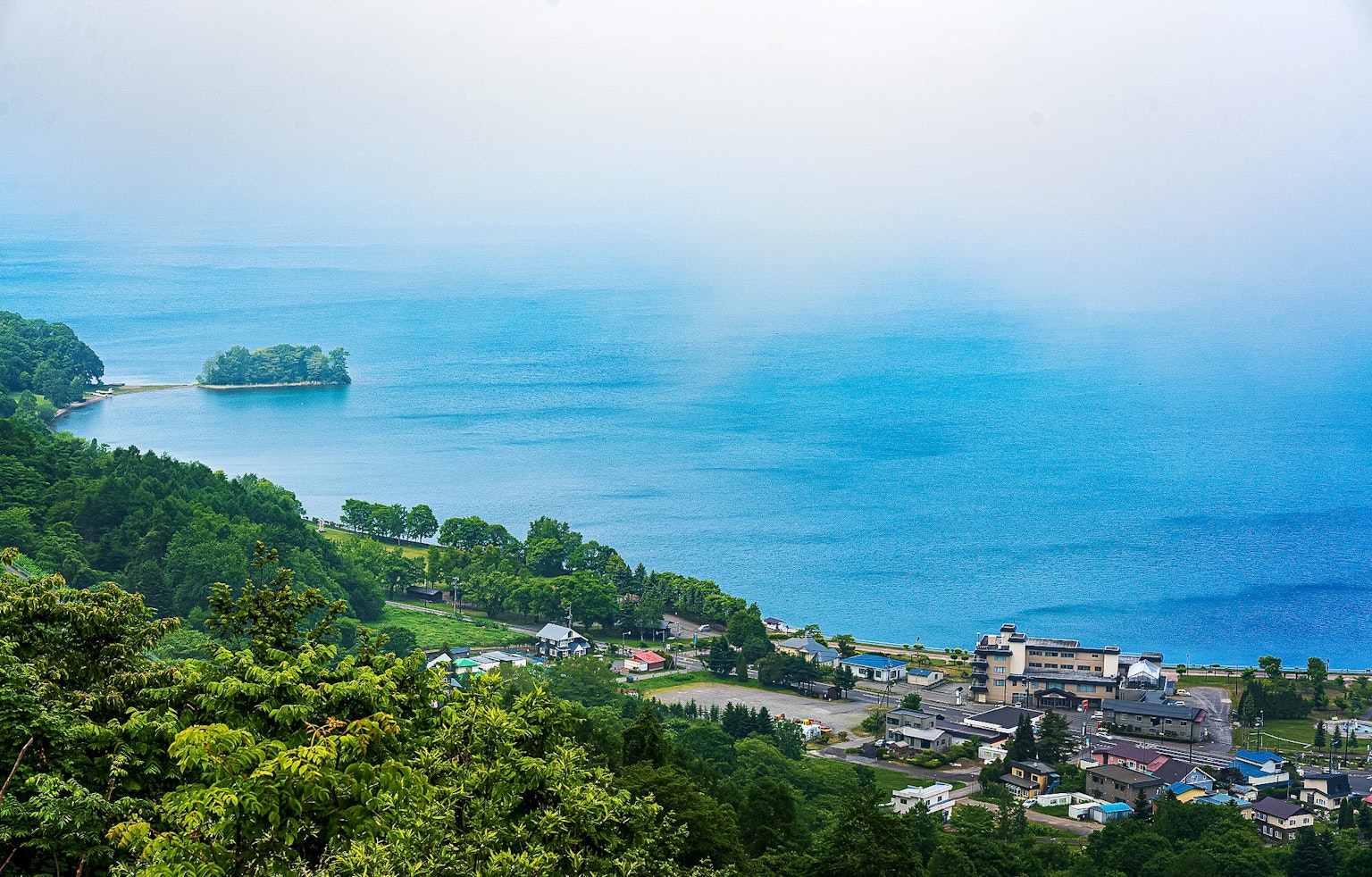 藍色海洋和綠色山脈環繞的小鎮風景
