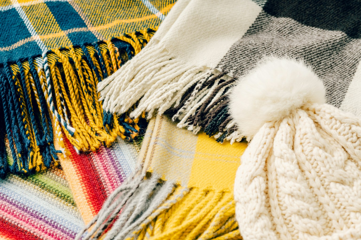 Nahaufnahme von bunten Schals und einer Strickmütze