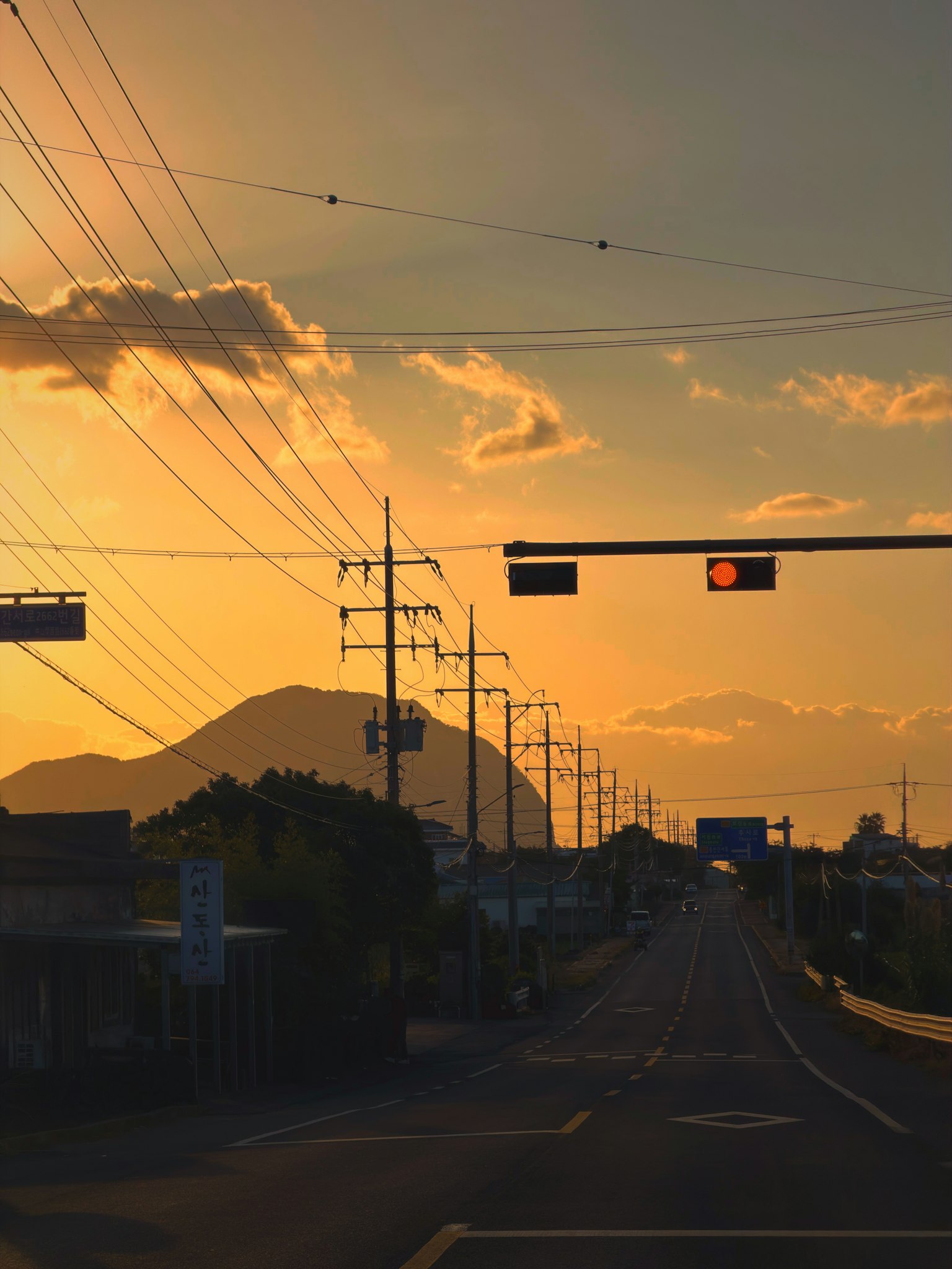 夕焼けの空と山のシルエットが見える道路の風景