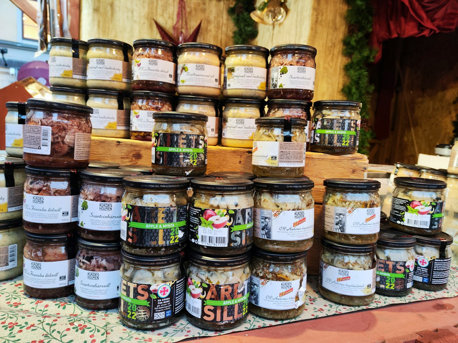 Verschiedene Gläser mit bunten Marmeladen und eingelegtem Gemüse auf einem Marktstand