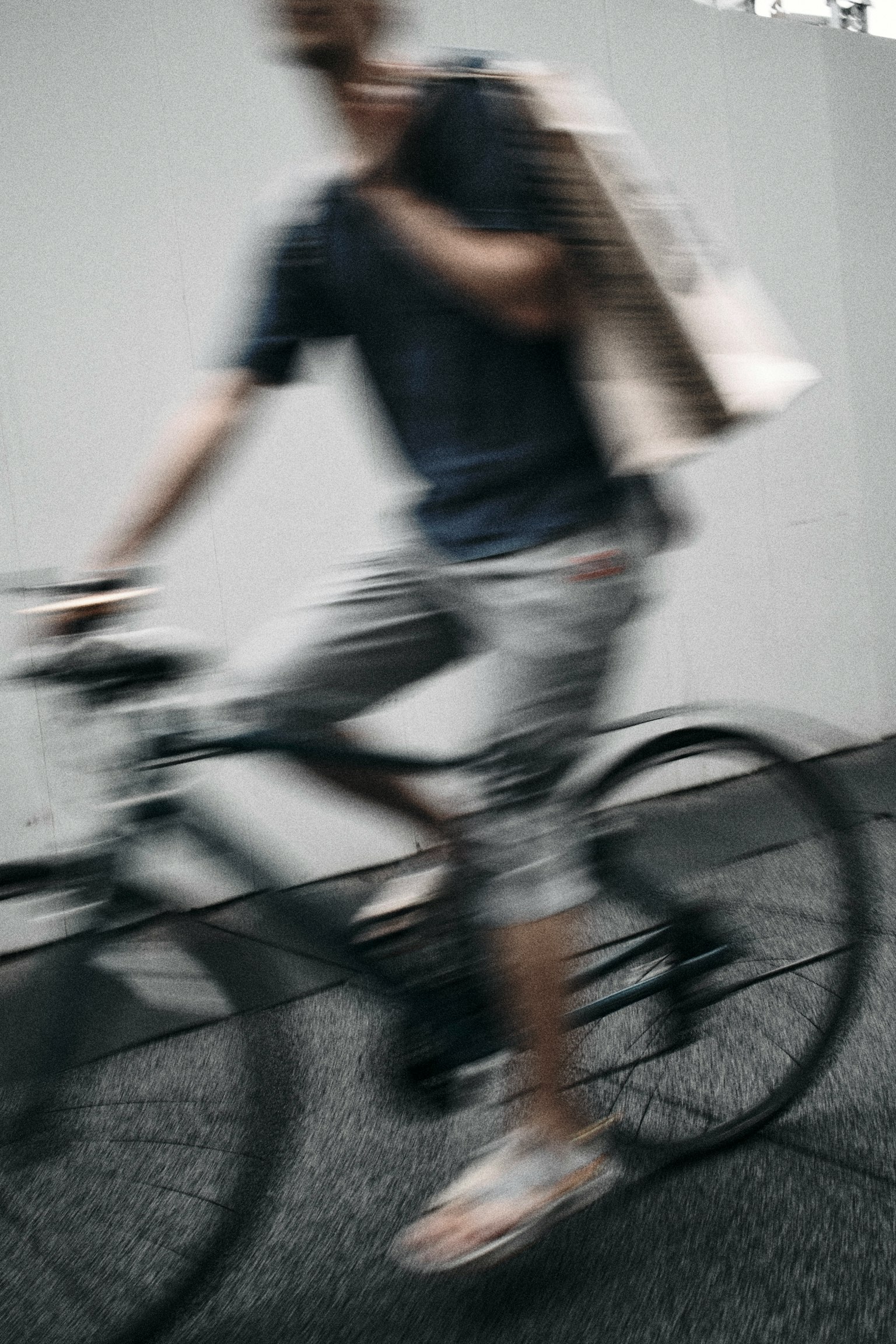 Uomo in bicicletta in movimento sfocato che tiene una borsa