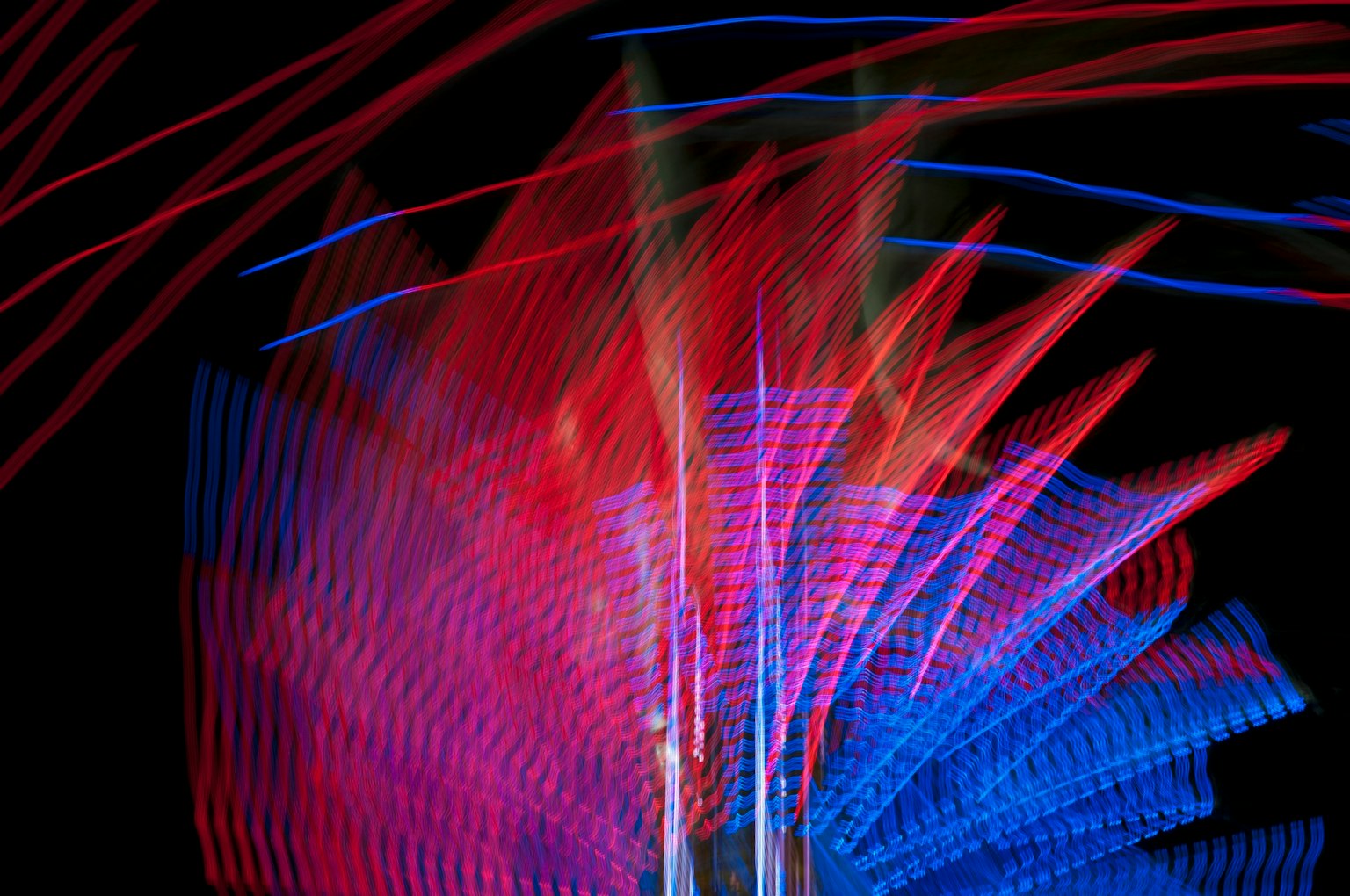 Vivid swirl of red and blue lights moving in darkness
