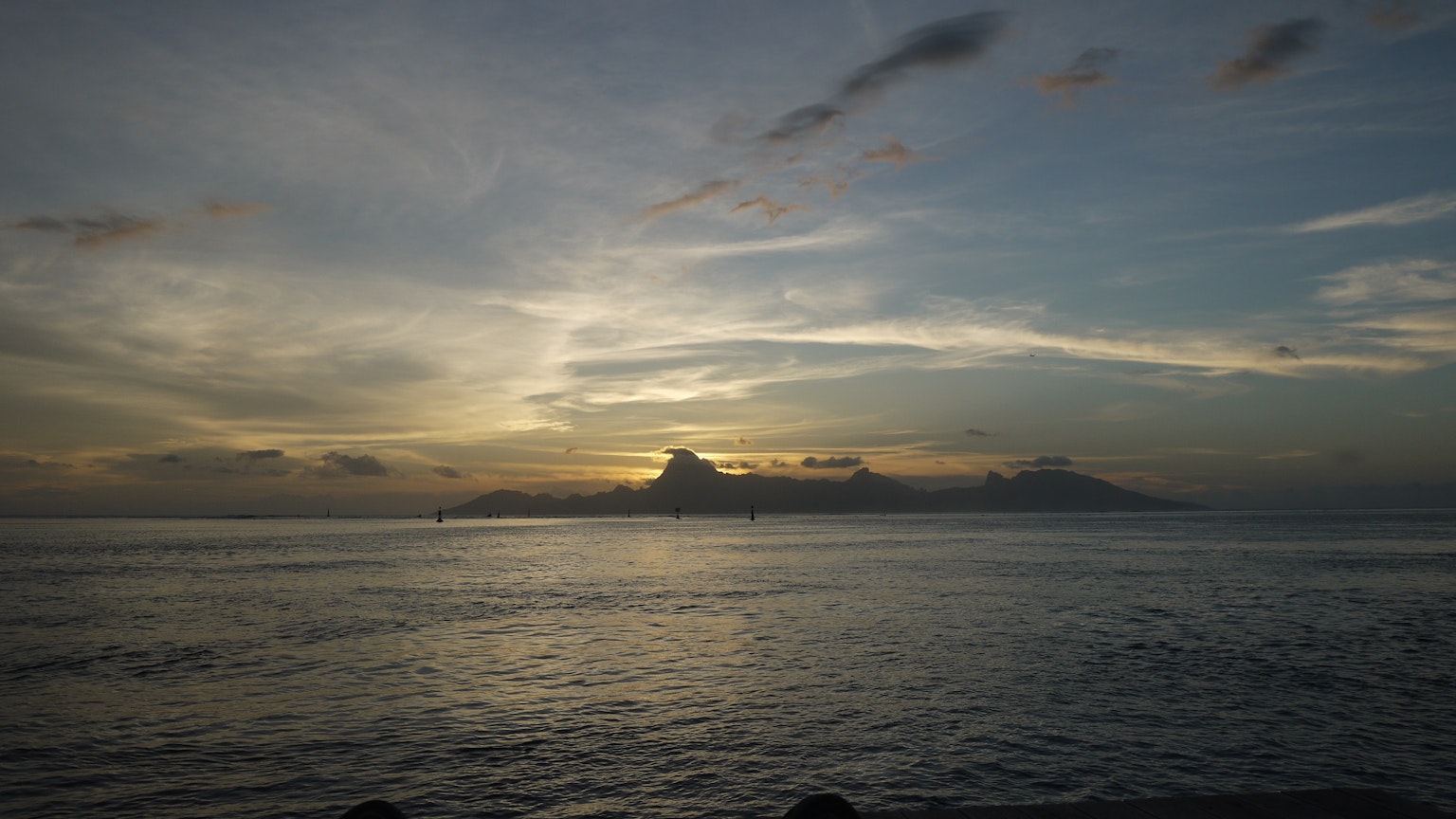 Mar tranquilo con una puesta de sol y nubes