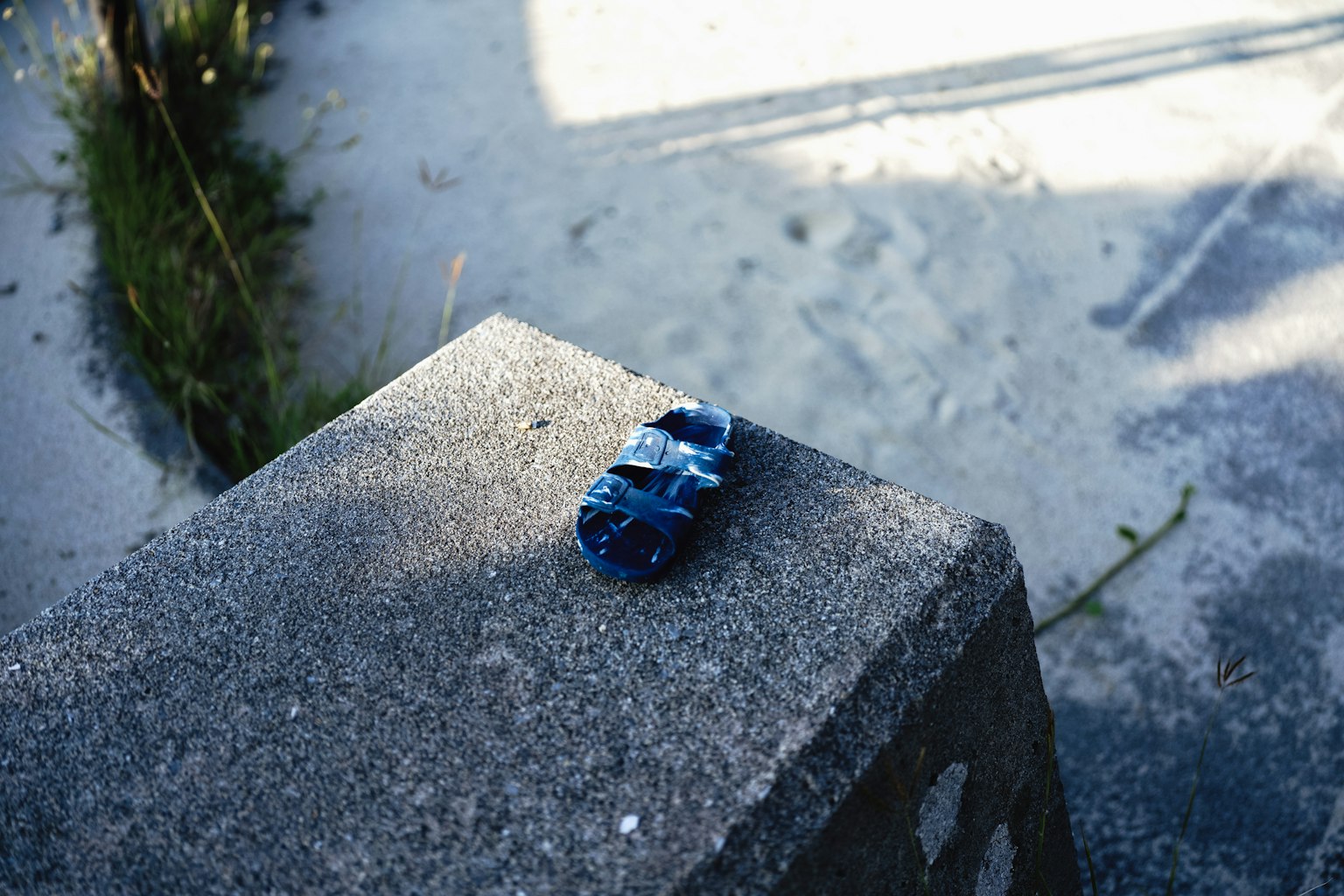 A blue stone resting on a concrete surface