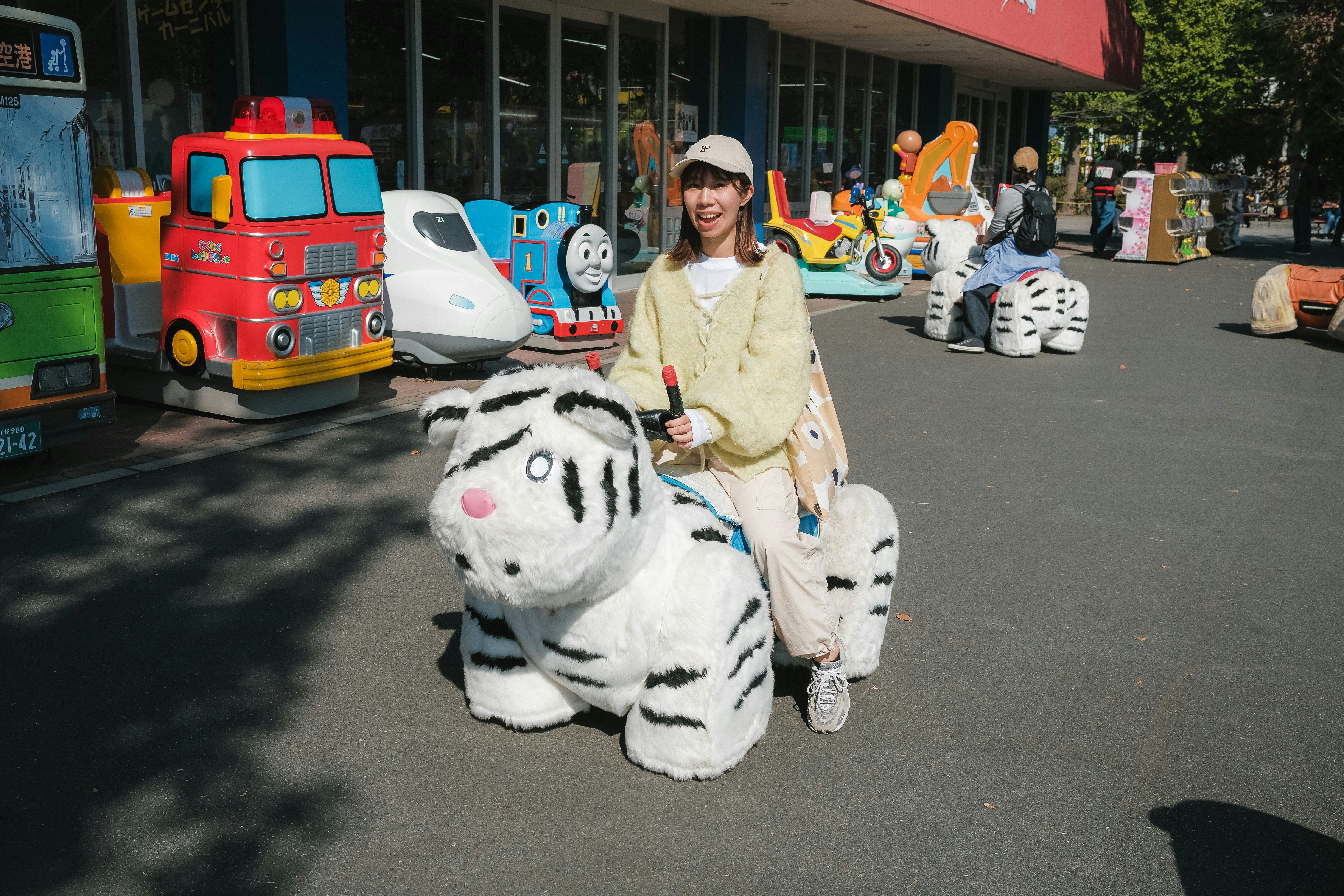 路上に並ぶキャラクターのぬいぐるみと遊園地風の車両